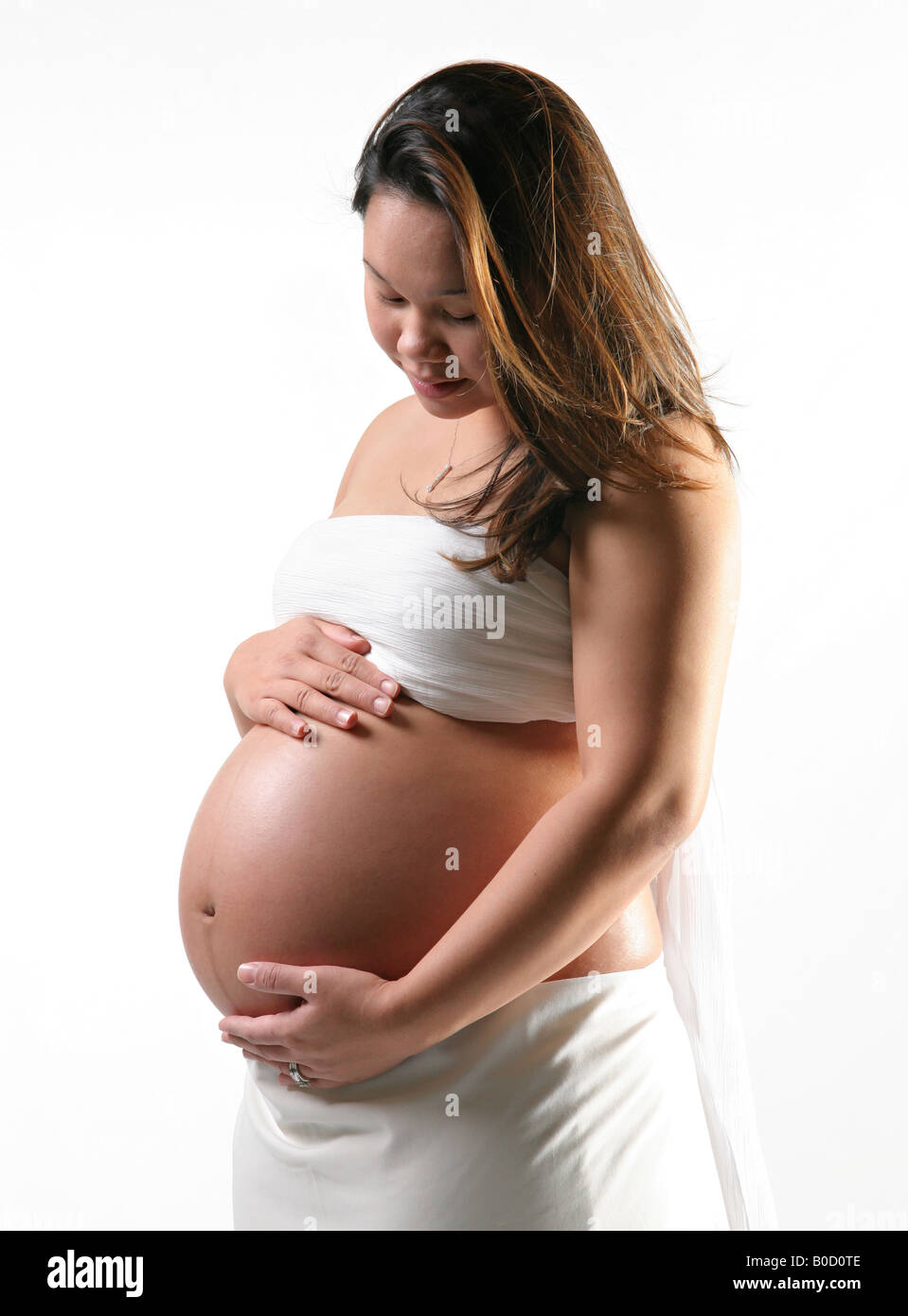 junge asiatische schwangere allein wiegt Gebärmutter Stockfoto