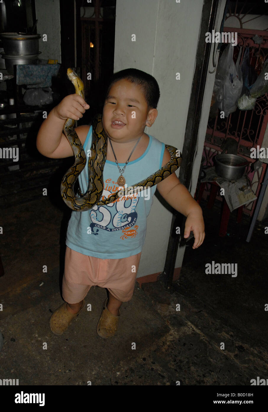 Thai kleine Junge spielt mit seinem Haustier (Schlange), Bangkok thailand Stockfoto
