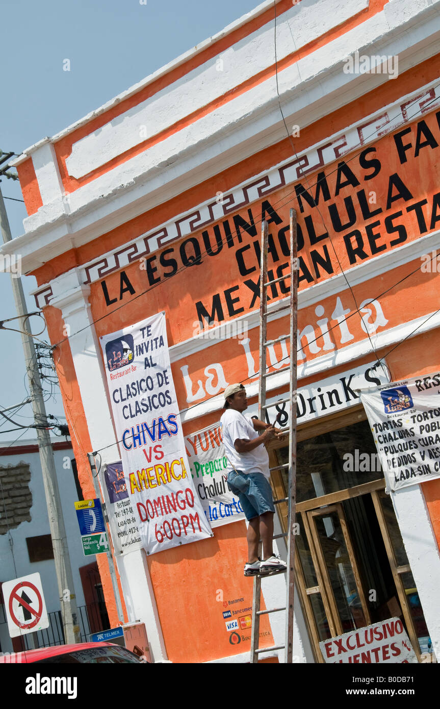Zeichen Schriftsteller Stand auf einer Leiter arbeiten auf die Malerei der neuen Grafiken für ein mexikanisches Restaurant in Cholula, Mexiko. Stockfoto