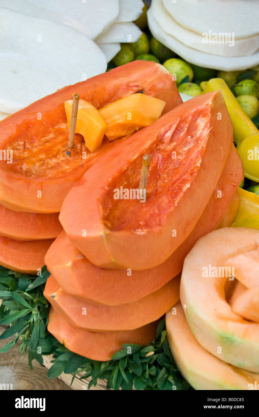 Geschnittener Papayas zum Verkauf auf der Straße Ecke in Puebla, Mexiko. Gestapelt und zusammen mit Holz Spieß Stockfoto