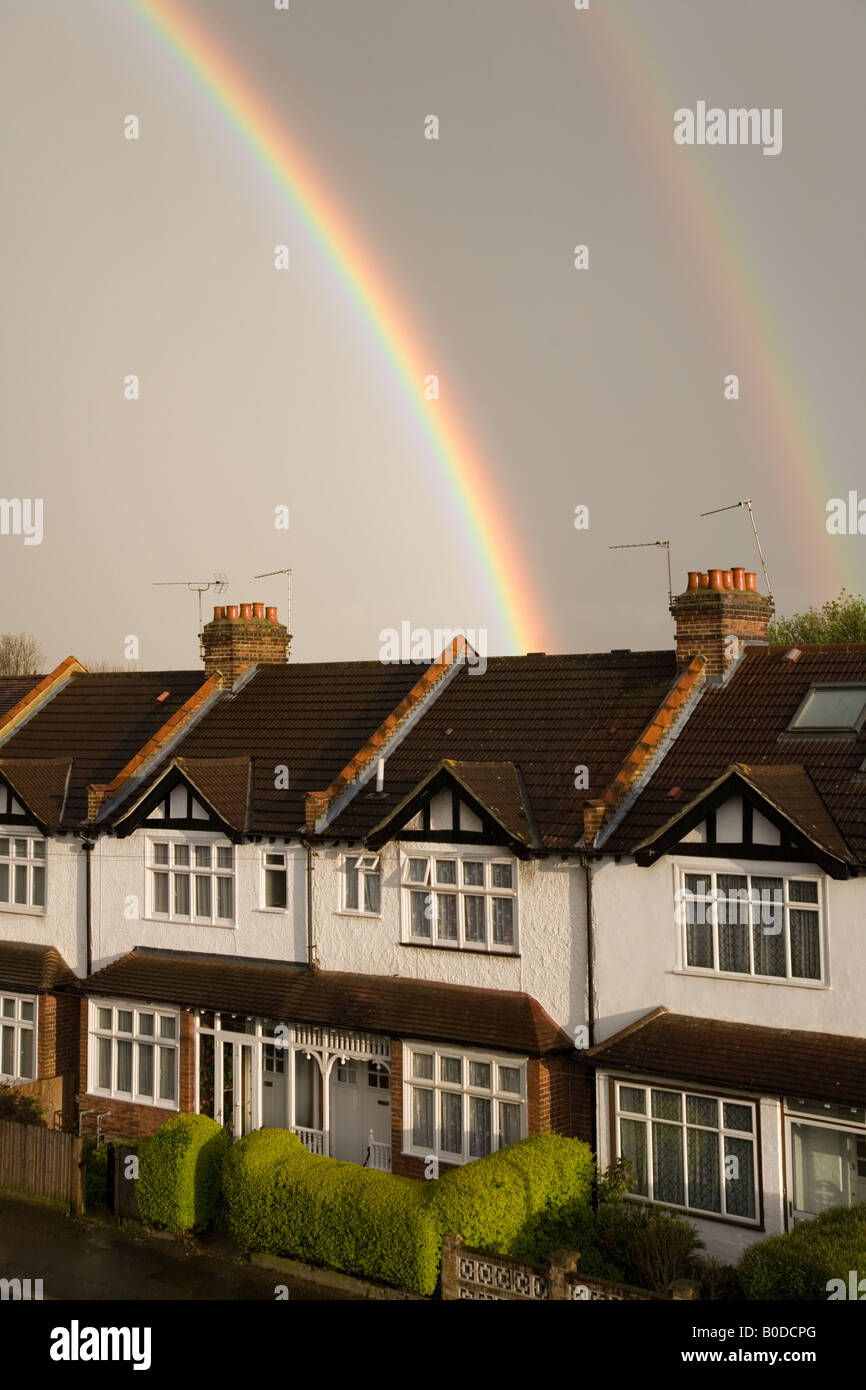 Regenbogen über Terrasse der Häuser in einem Vorort London Surrey uk Stockfoto