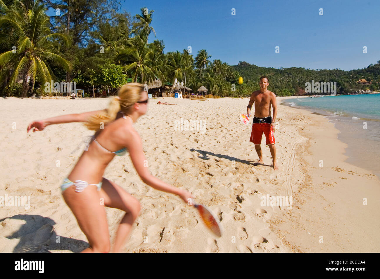 Ein paar genießt ein lustiges Spiel von Paddle Ball an einem tropischen Strand in Thailand Stockfoto