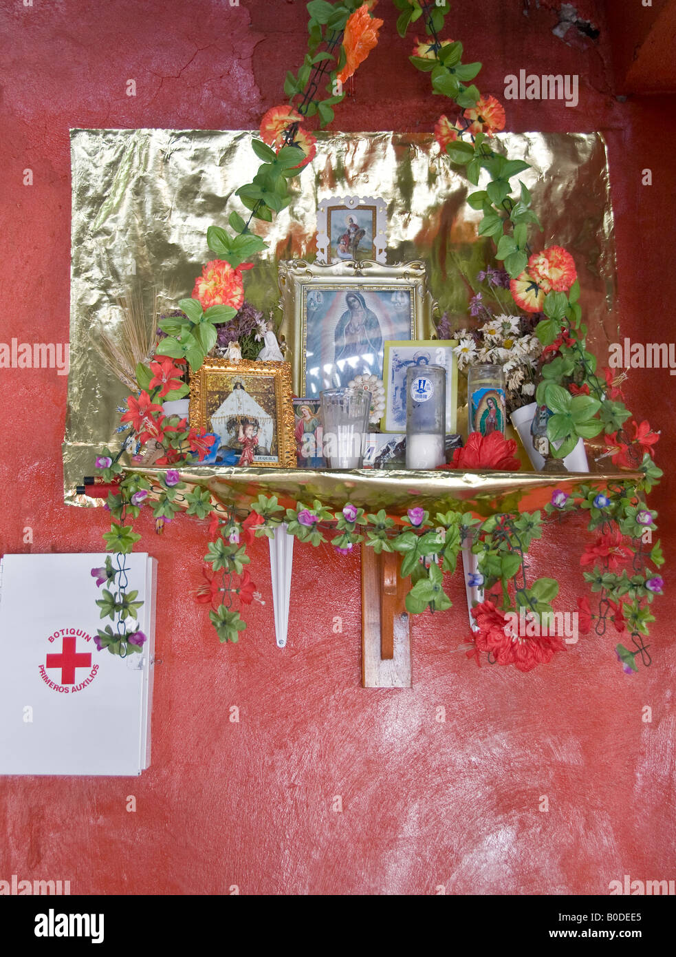 Gerahmte Bilder und Ikonen der Jungfrau von Guadalupe auf Regal Schrein gelegt. Mit Kerzen, Lichterketten und Plastikblumen. Stockfoto