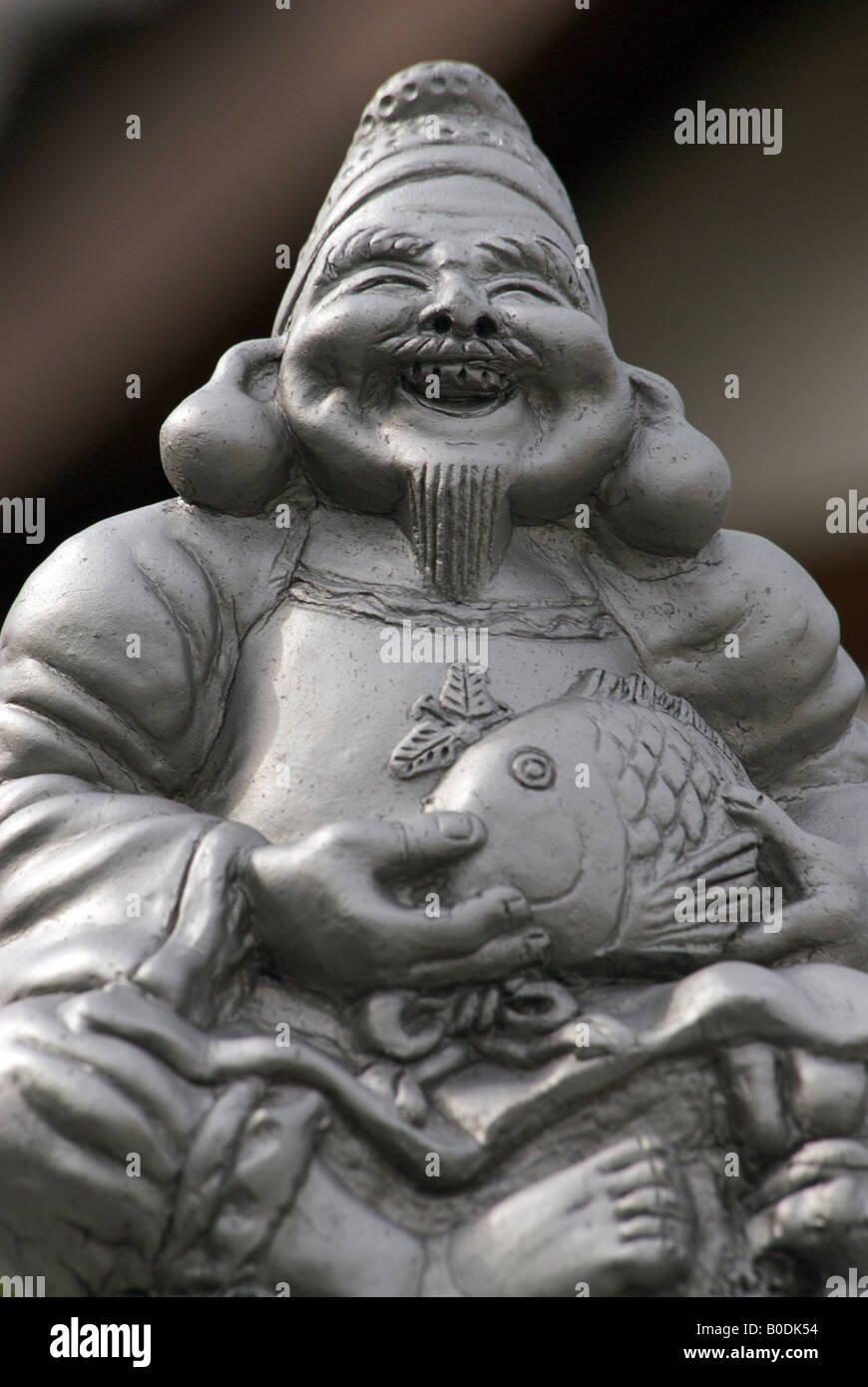Geformte Dachziegel an Traufe. Japan.Ebisu, Gott der Fischer oder Kaufleute tragen eine Dorade. Eines der sieben japanischen Glücksgötter Stockfoto