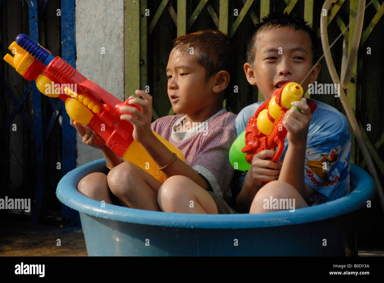 zwei kleine Junge sitzen im Kunststoff-Eimer mit Wasser genießen Songkran Festival, Bangkok, thailand Stockfoto