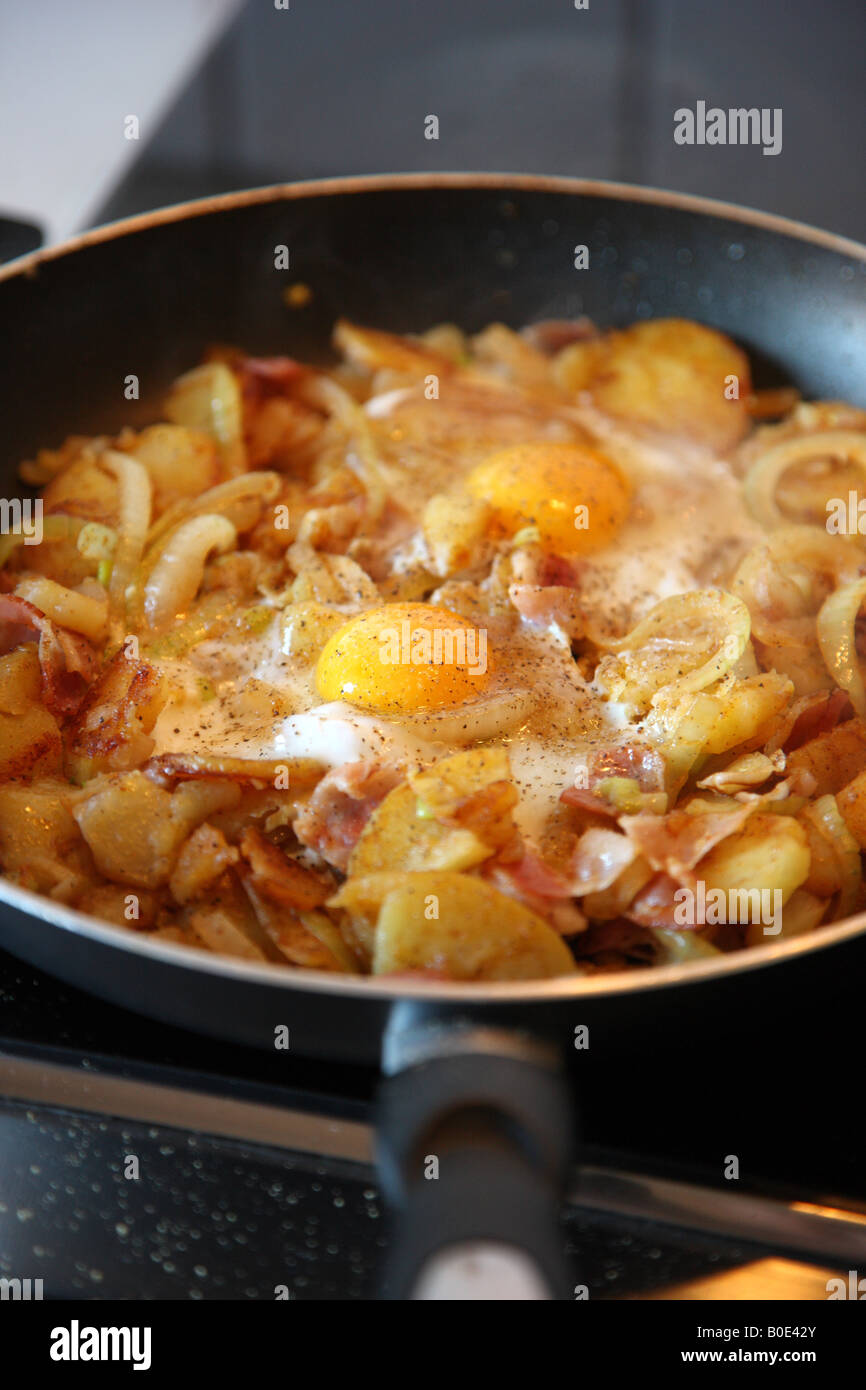 Bratkartoffeln mit Zwiebeln, Spiegelei in der Pfanne Stockfoto