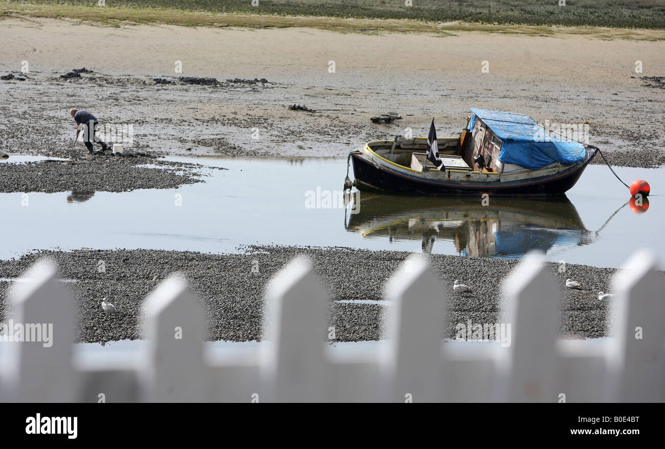 Ein Mann arbeitet in der Nähe der alten Boote in Shoreham West Sussex Stockfoto