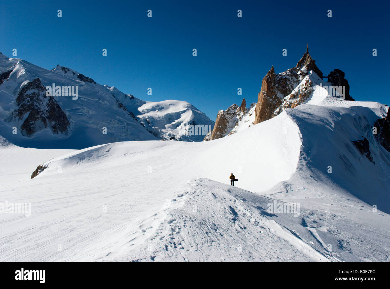 Snowboarder am Grat in Richtung Grand Envers du Plan Variante von Vallée Blanche, Aiguille du Midi im Hintergrund laufen Stockfoto