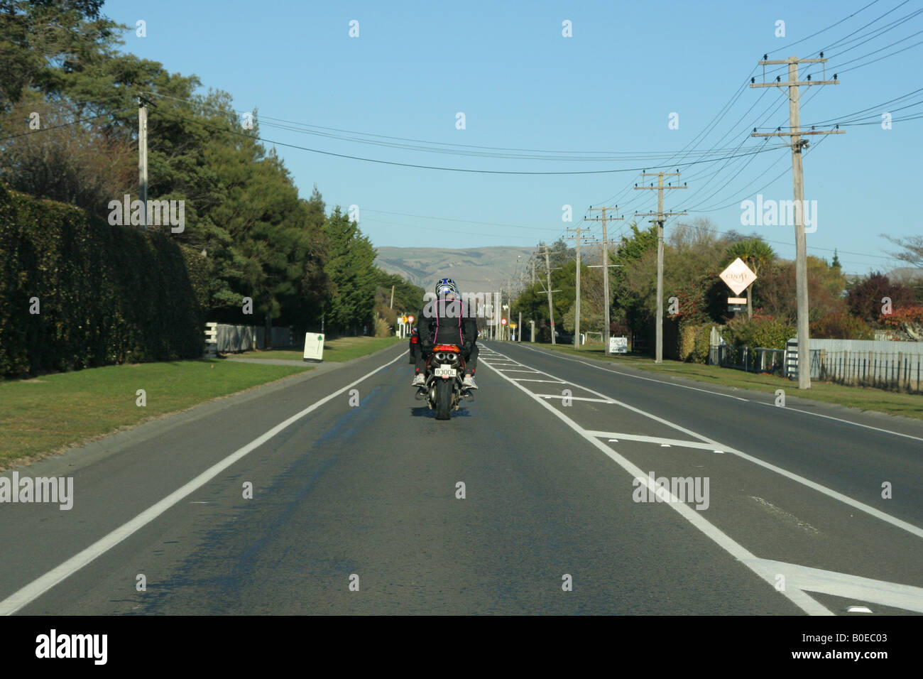 Motorradfahrer mit Sozius fahren in die Stadt. Stockfoto
