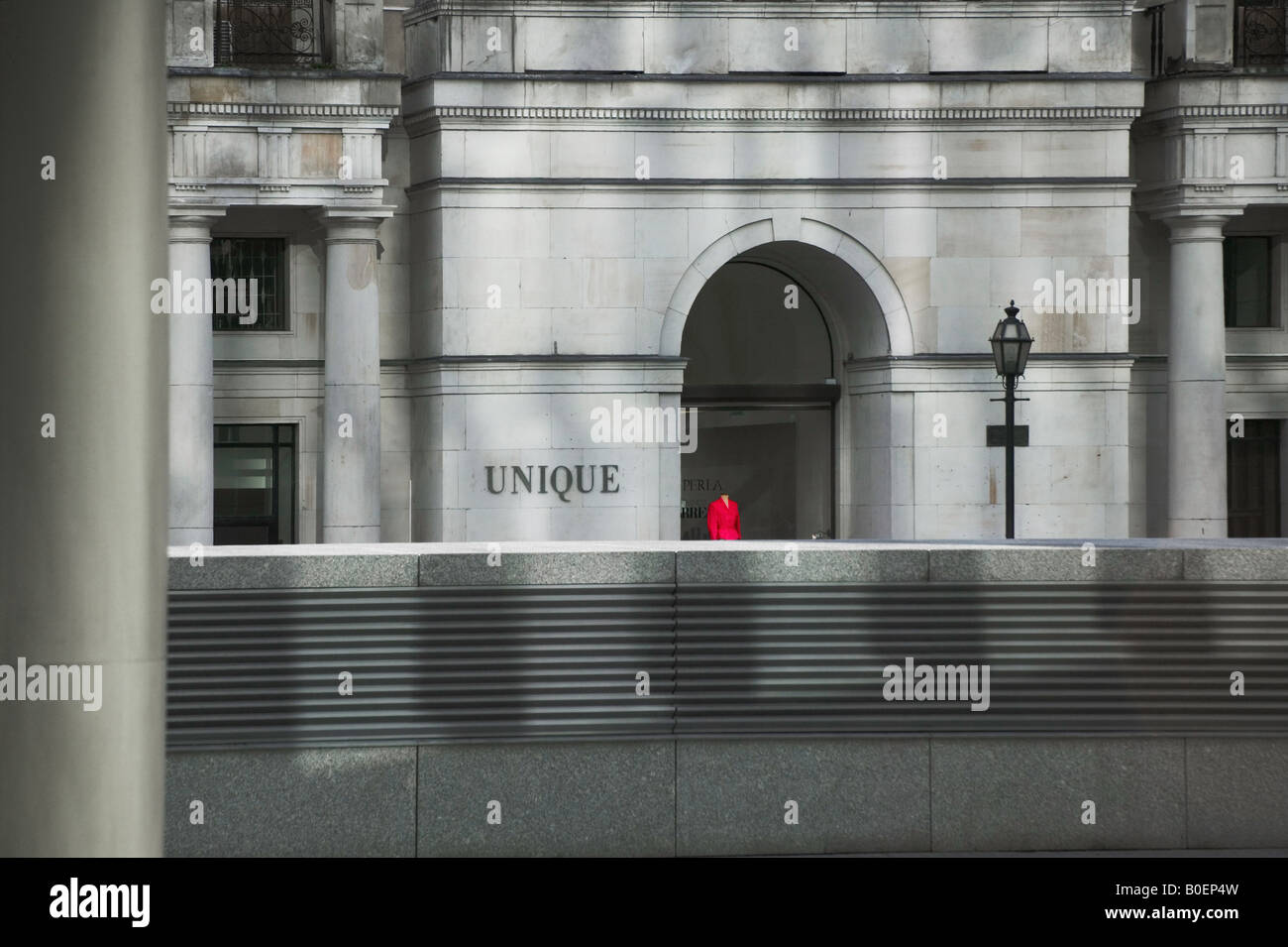 Ein Modell in rot im Schaufenster steht in einem grauen Gebäude Warschau Polen Stockfoto