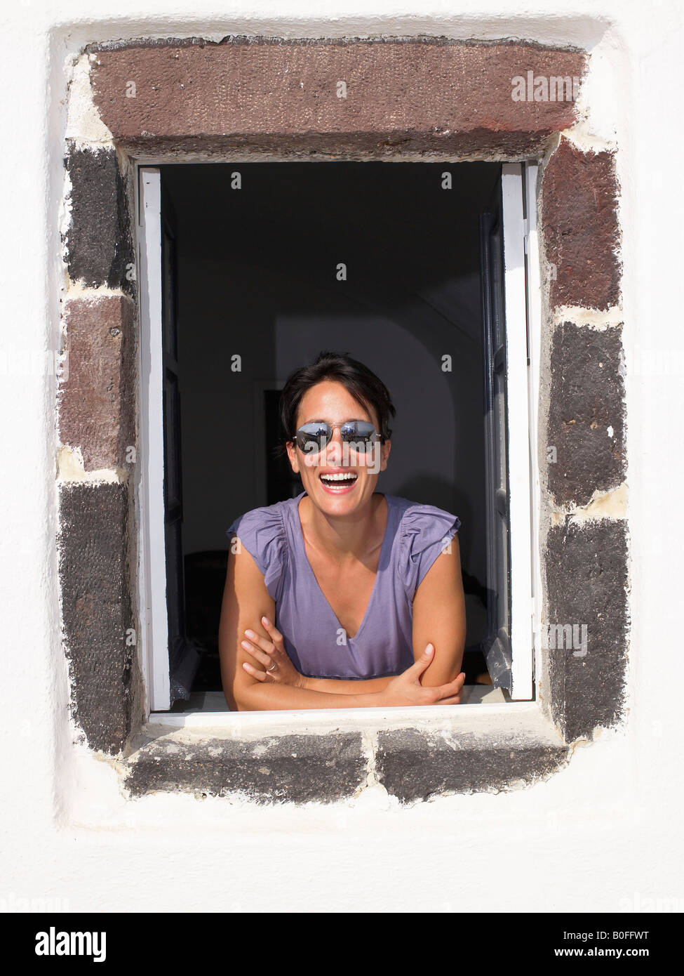 Frau, die durch Fenster, Lächeln Stockfoto