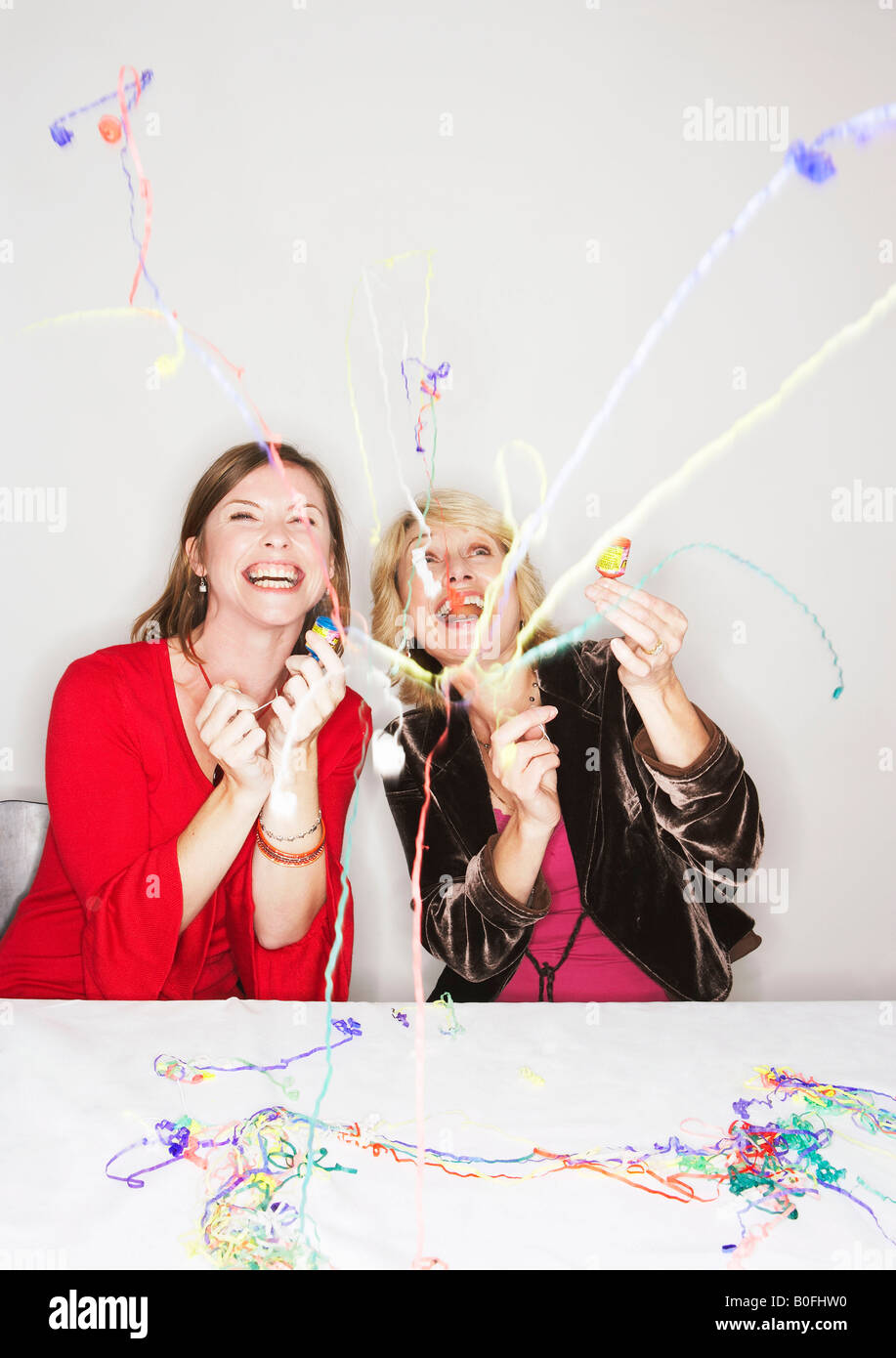 Zwei Frauen mit Party poppers Stockfoto
