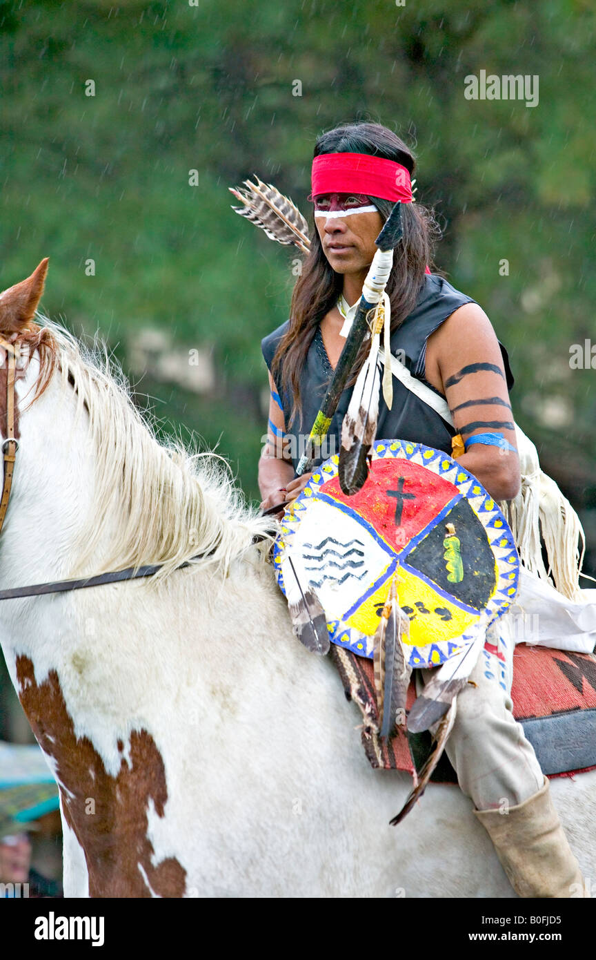 Eine Native American Indian geschmückt und gekleidet in traditionellen Krieger Kleidung reitet sein Pferd ohne Sattel. Stockfoto