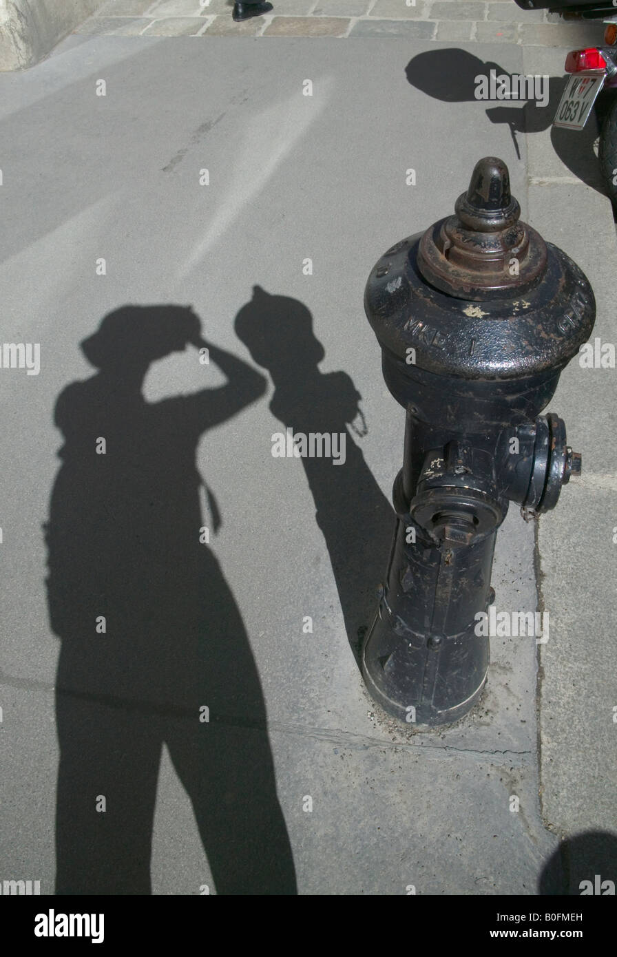 Schatten des Touristen fotografieren mit Hydranten auf dem Bürgersteig Wien Österreich Stockfoto