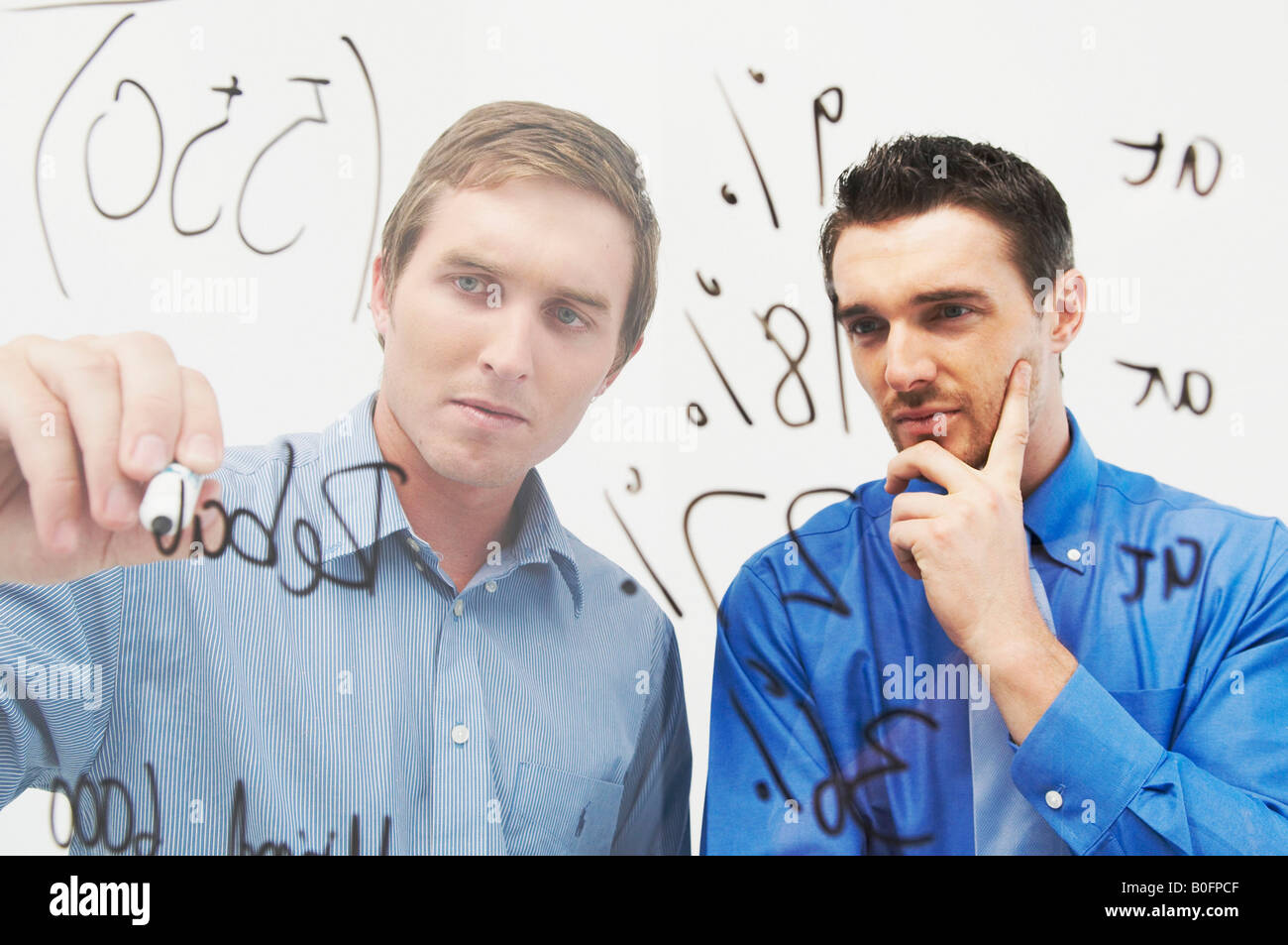 Zwei Männer schreiben auf Glasplatte Stockfoto