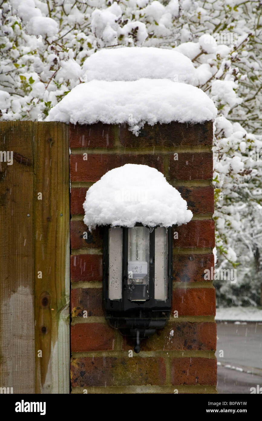 Eine schneebedeckte Sicherheit Licht auf einem gemauerten Pfeiler Stockfoto