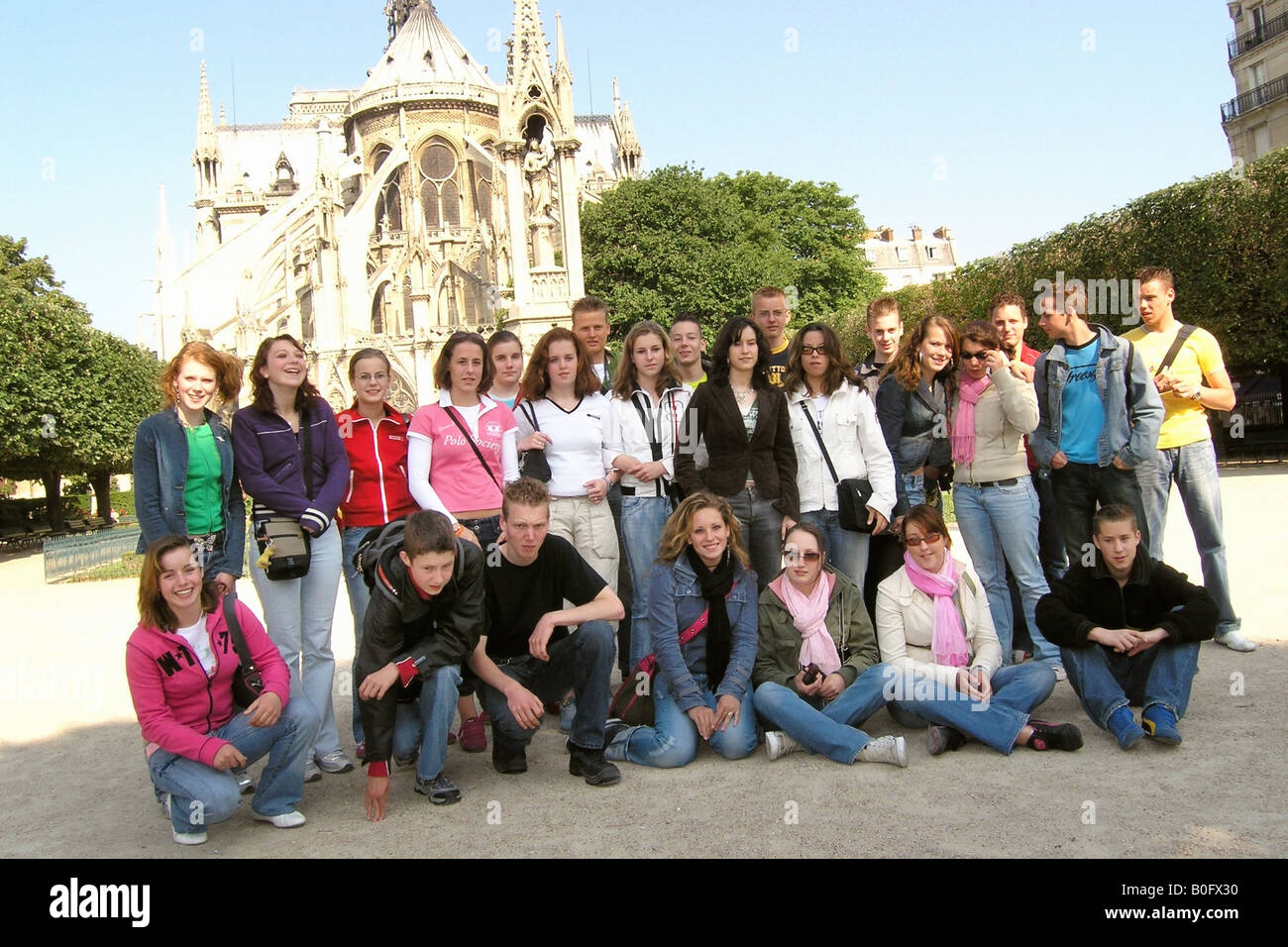 Schulgruppe der kaukasischen Teenager posiert für die Kamera vor Notre Dame Paris Frankreich Stockfoto