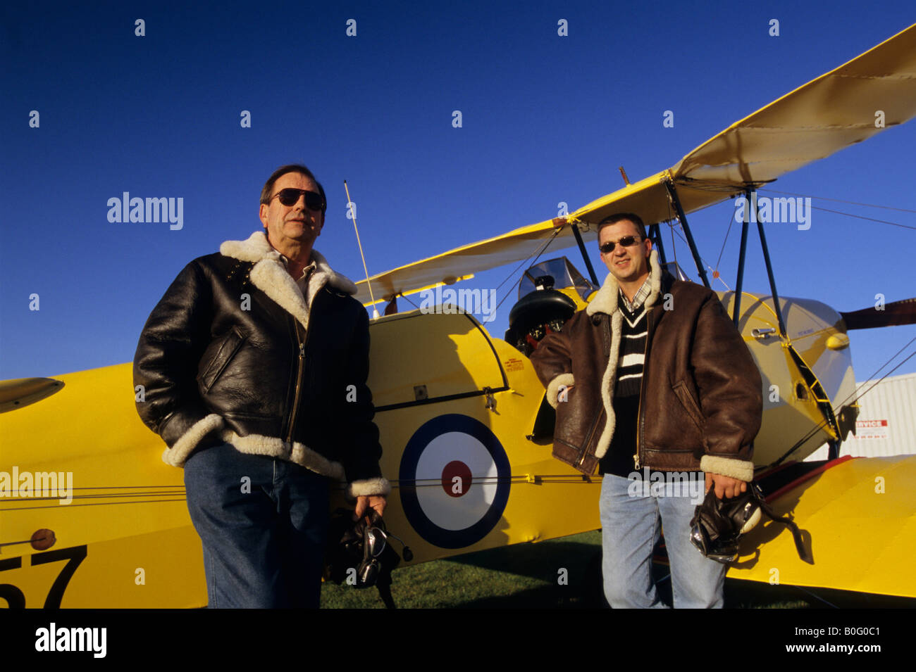 Zwei Piloten mit fliegenden Jacken in der Nähe von alten Trainer Doppeldecker De Havilland DH 82c Tiger Moth Stockfoto