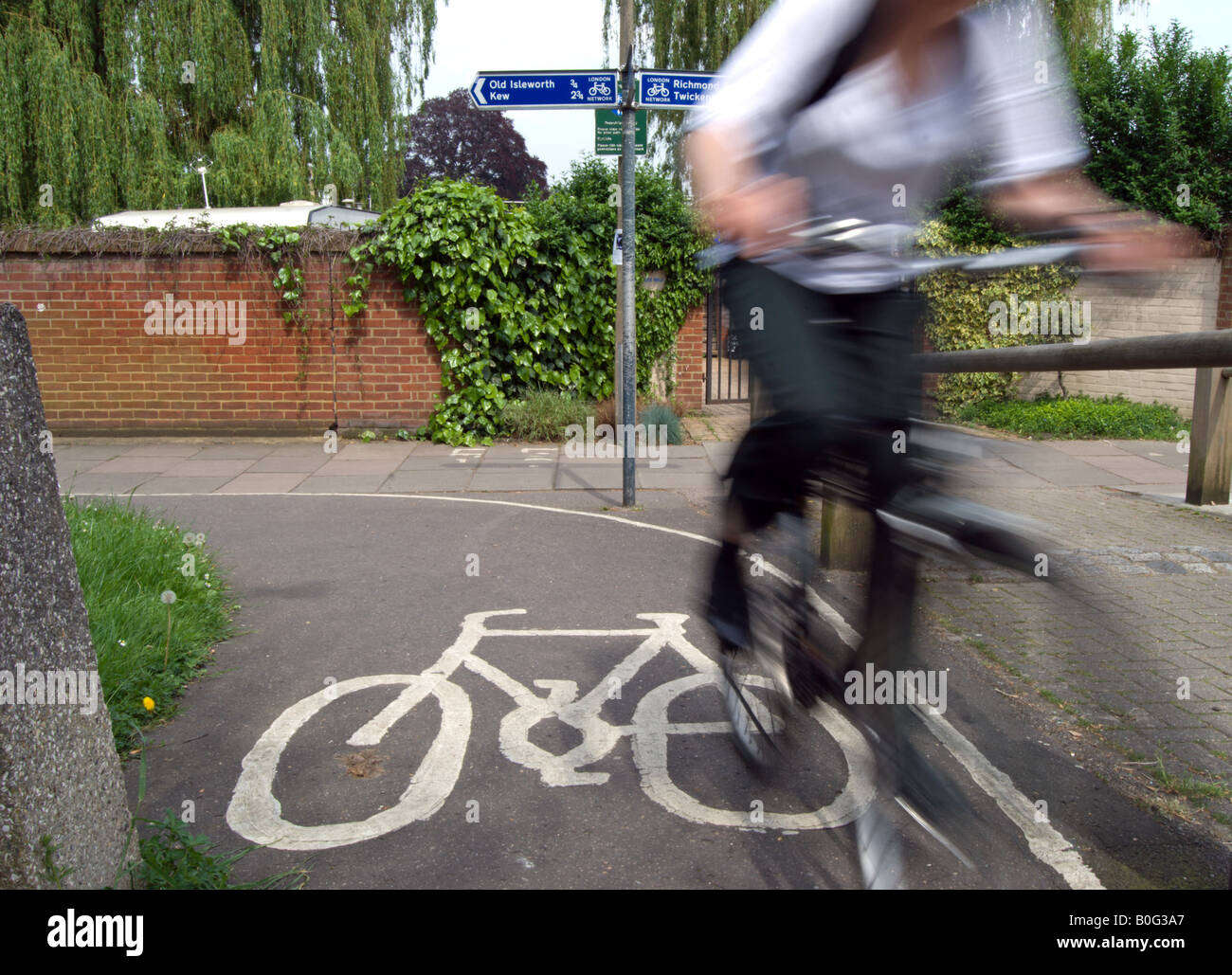 verschwommene weibliche Radsportler, die auf britischen Radweg mit weißen Fahrrad Markierung am Boden angegeben. Stockfoto