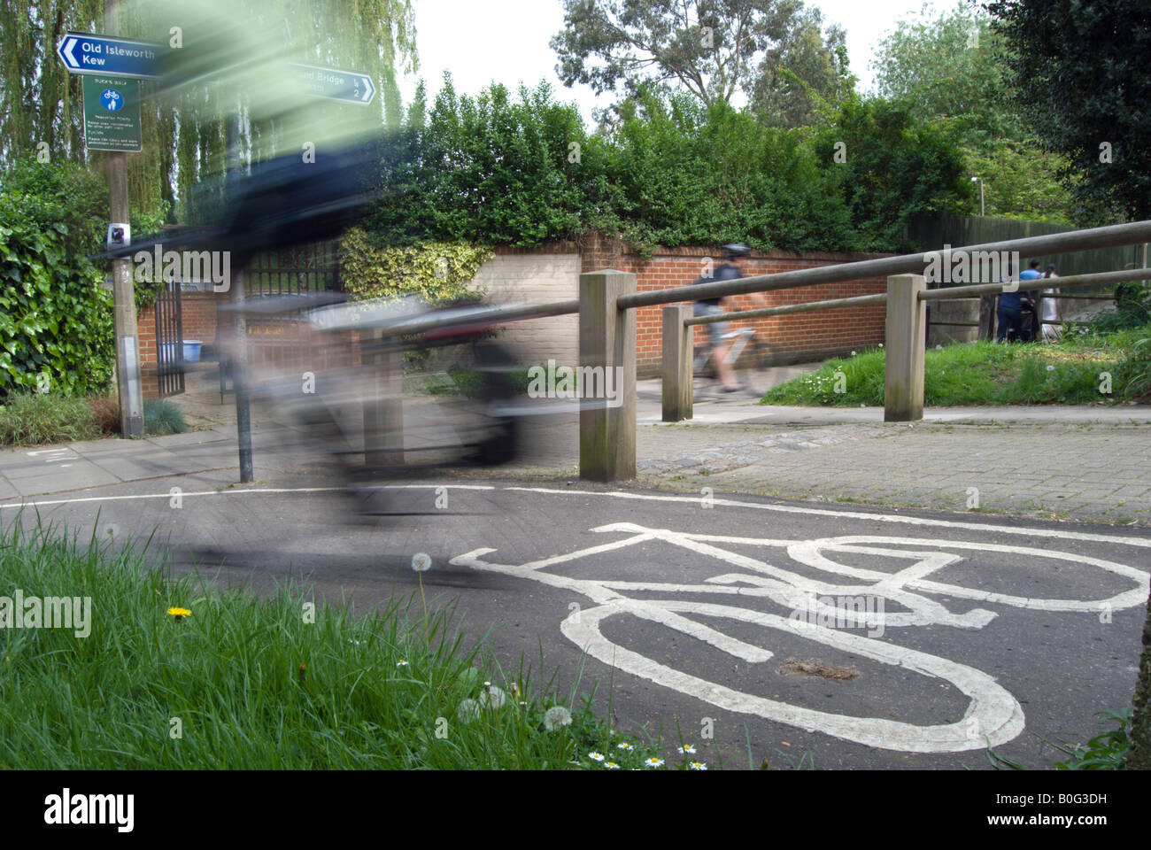 verschwommene Radsportler, die auf britischen Radweg mit weißen Fahrrad Markierung am Boden angegeben. Stockfoto