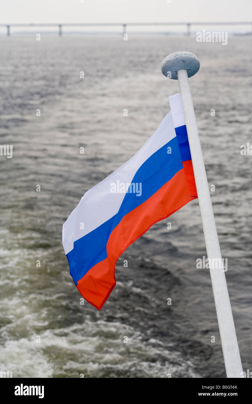 Russische Flagge auf Kreuzfahrtschiff auf Wolga mit neuen Straßenbrücke, Volgograd (in der Nähe von Stalingrad), Russland, Russische Föderation Stockfoto