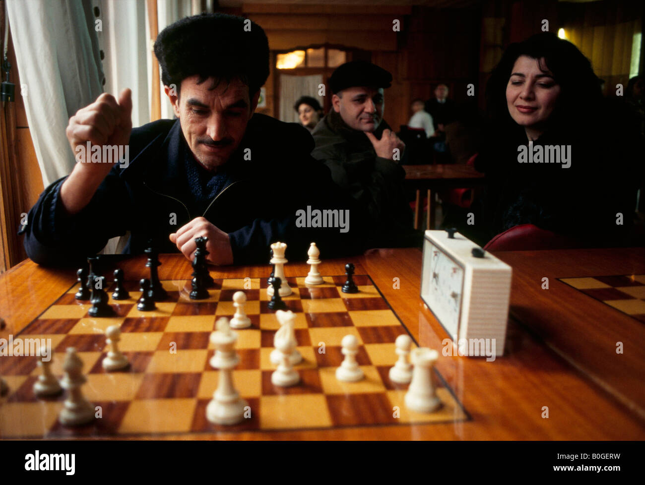 Ein Azeri Schachspieler in Anbetracht seiner nächsten bewegen sich mit einem Schachclub, Baku, Aserbaidschan. Stockfoto