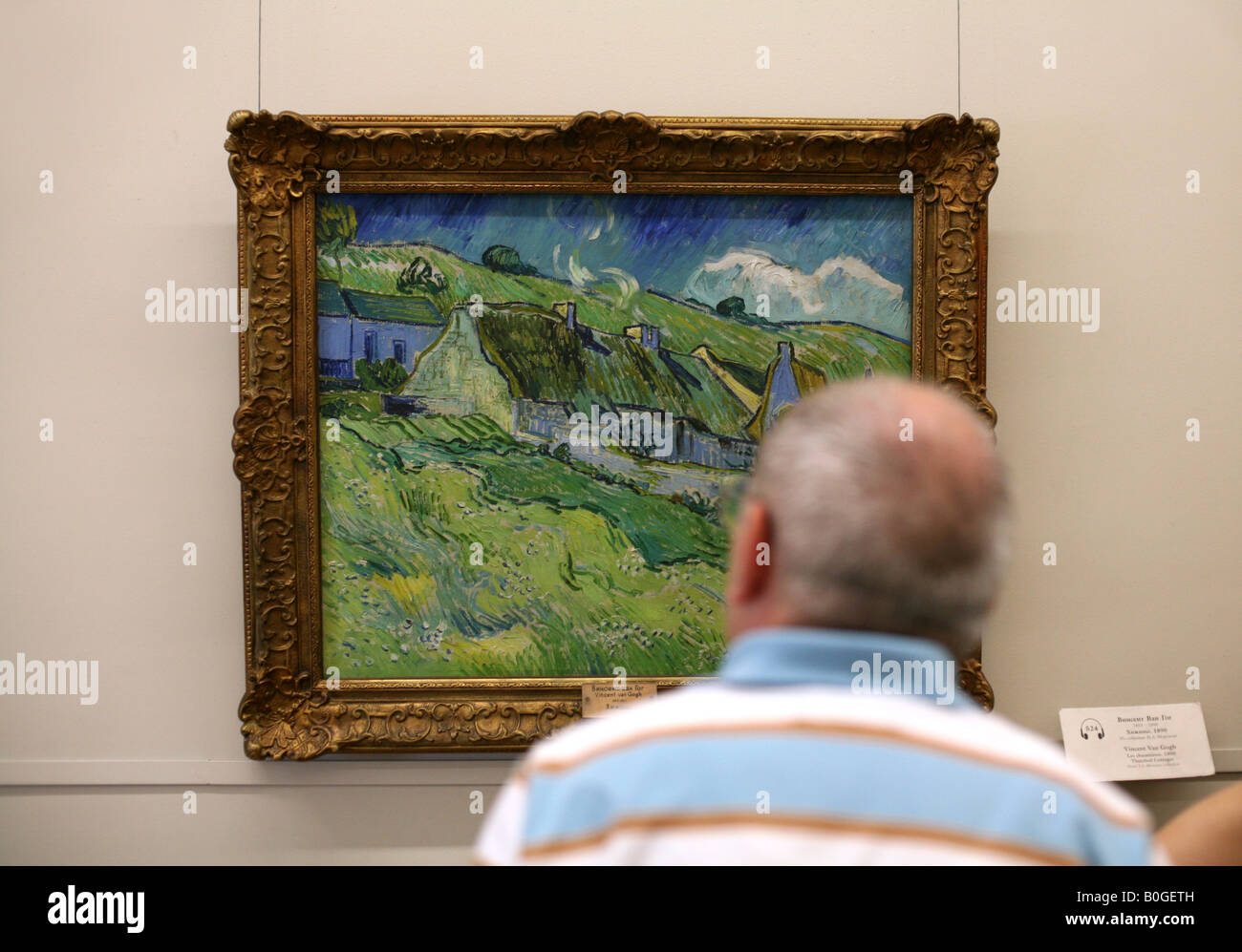 Besucher betrachten das Gemälde von Vincent van Gogh "Les Chumieres" ("The strohgedeckten Cottages") in der Eremitage Museum, Russland Stockfoto