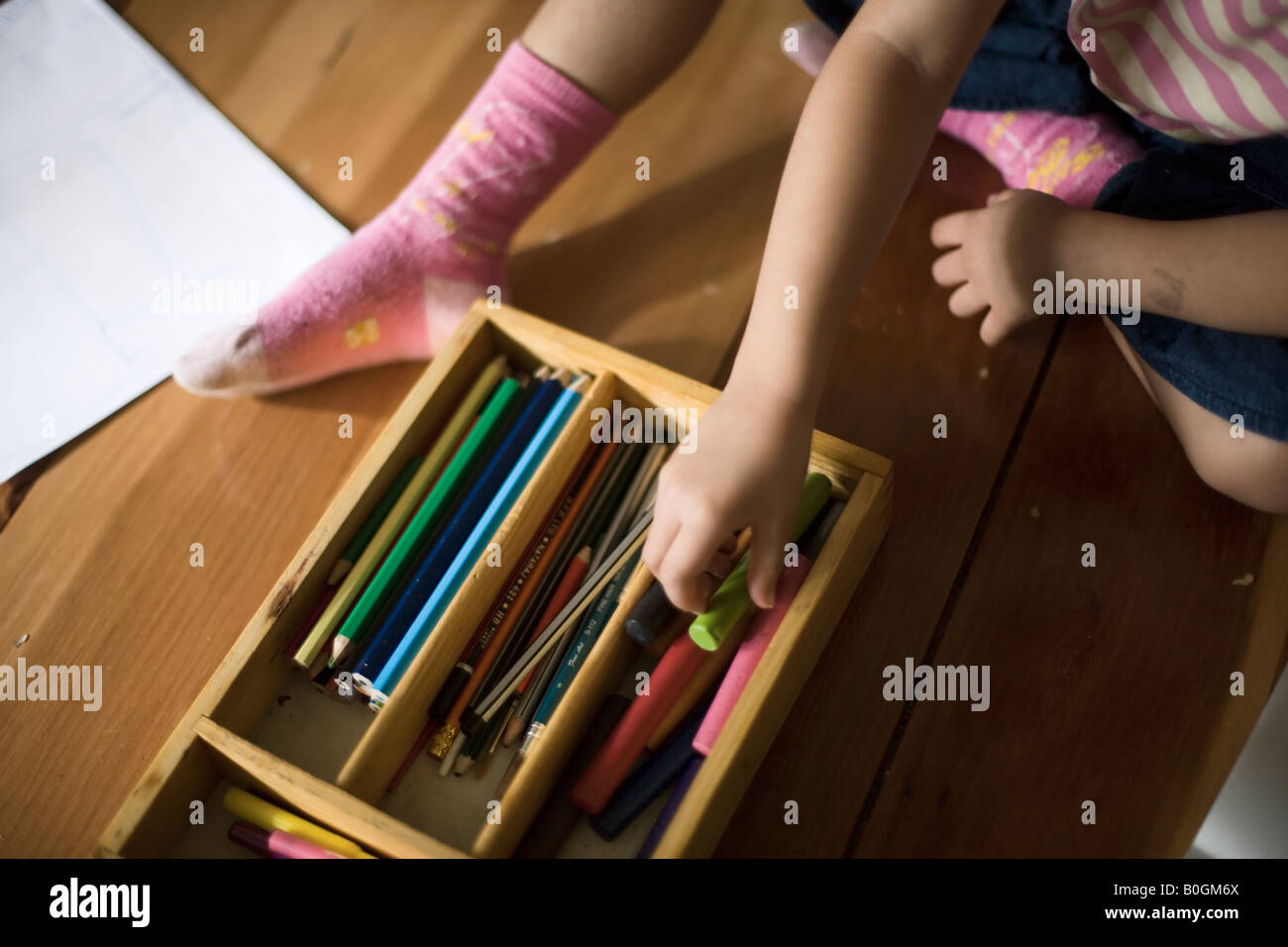 Mädchen von vier Jahren wählt Buntstifte zum Ausmalen Stockfoto