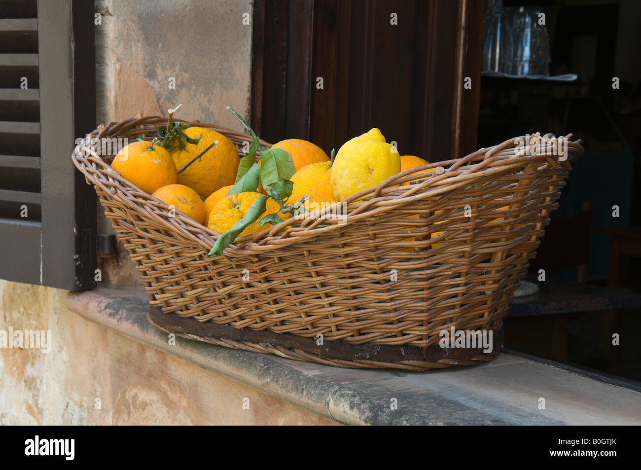 Ein Korb mit Zitrus Früchte und Fenster Rollladen Altstadt Alcudia Mallorca Spanien Stockfoto