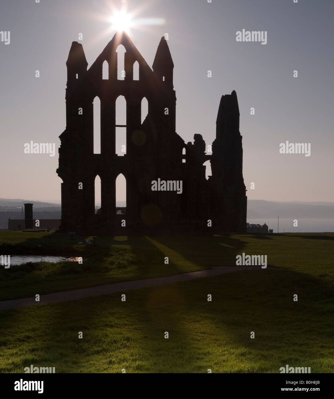Whitby Abtei Yorkshire mit einer untergehenden Sonne über die Ost-Giebel-silhouette Stockfoto