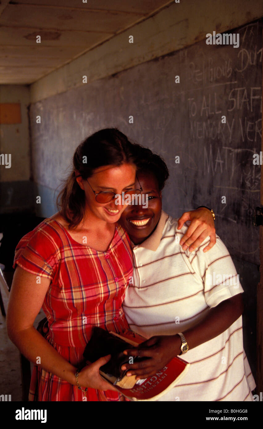 Ein VSO Englischlehrer umarmt einen Schüler an einem Gymnasium, Joss, Nigeria. Stockfoto