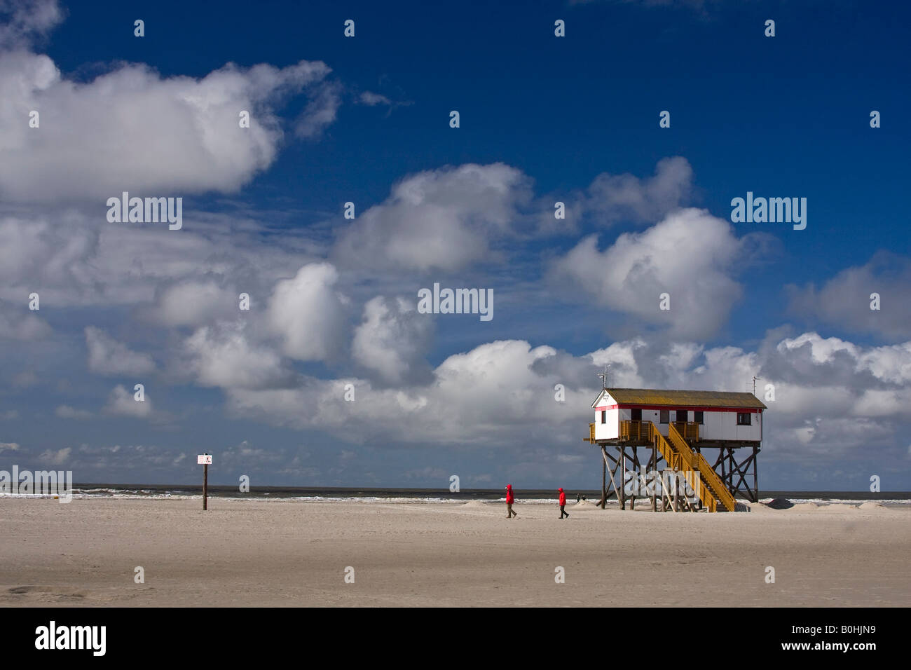 Menschen zu Fuß vorbei an einem Haus auf Stelzen am Strand von der Badeort St. Peter-Ording, Nordsee-Küste, Nordfriesland, Sc Stockfoto