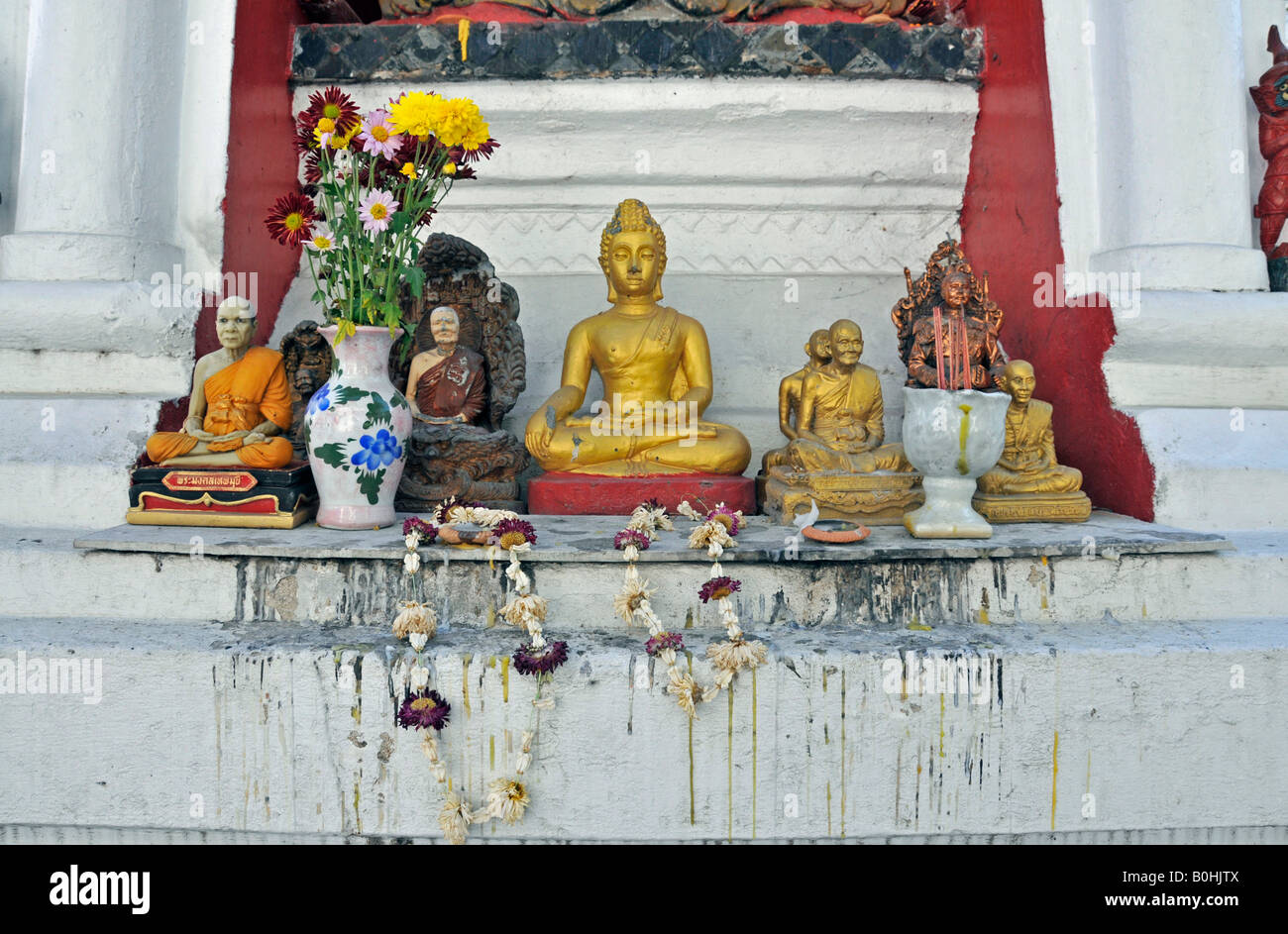 Freuen Sie sich vor einer Buddhastatue, Figuren von Mönchen und Blumen Girlanden, Yaang Kuong Tempel Wat Chiang Mai, Thailand, Süd Stockfoto