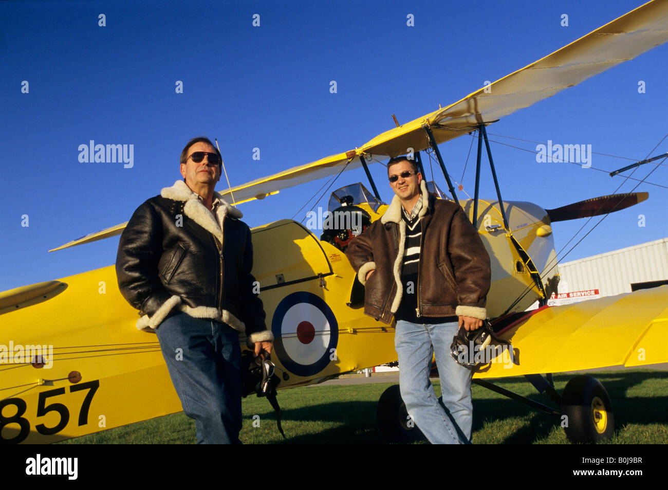 Zwei Piloten mit fliegenden Jacken in der Nähe von alten Trainer Doppeldecker De Havilland DH 82c Tiger Moth Stockfoto