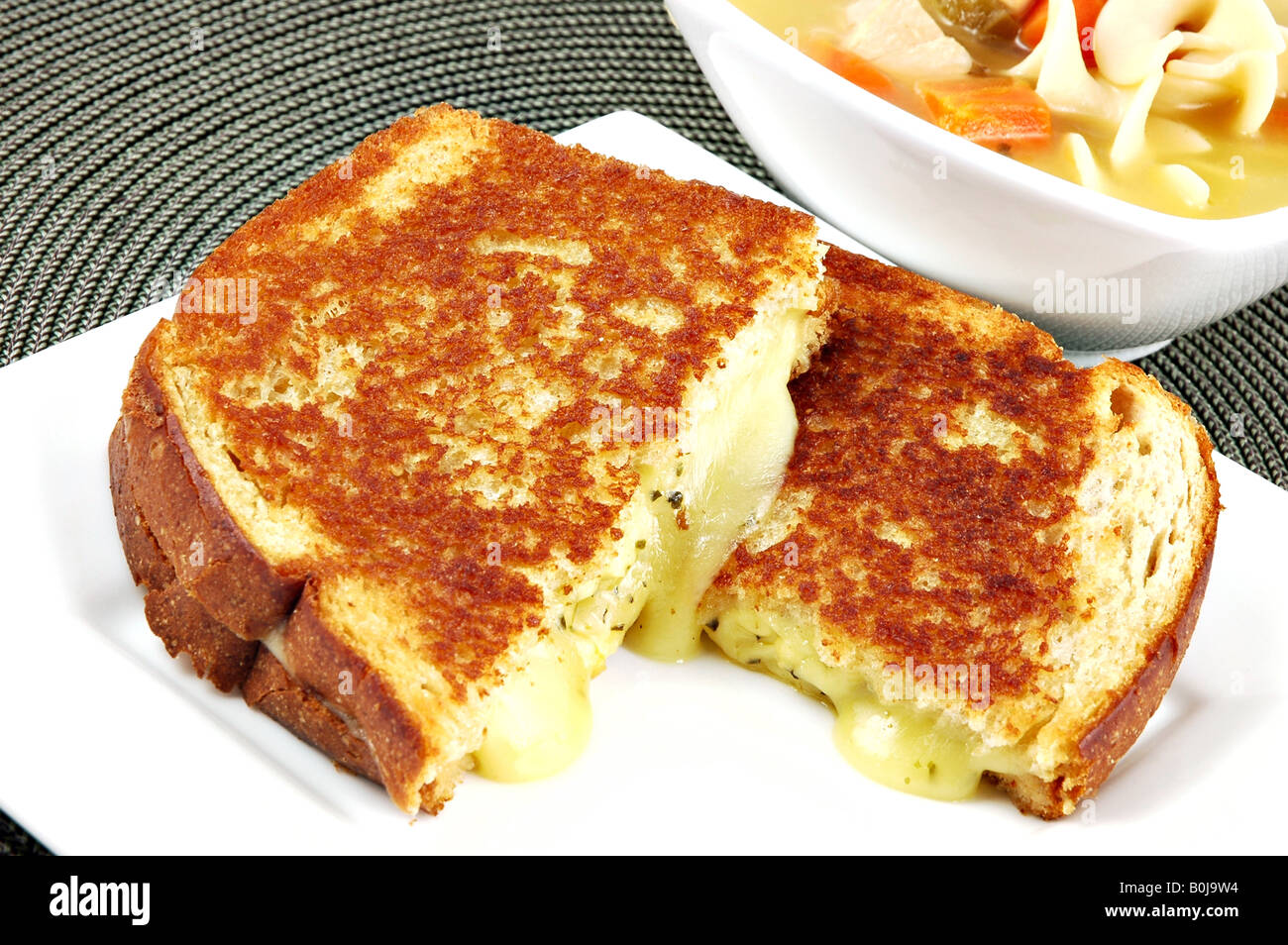 Mittagessen mit einem Käse-Sandwich und eine Schüssel mit Huhn-Nudelsuppe Stockfoto