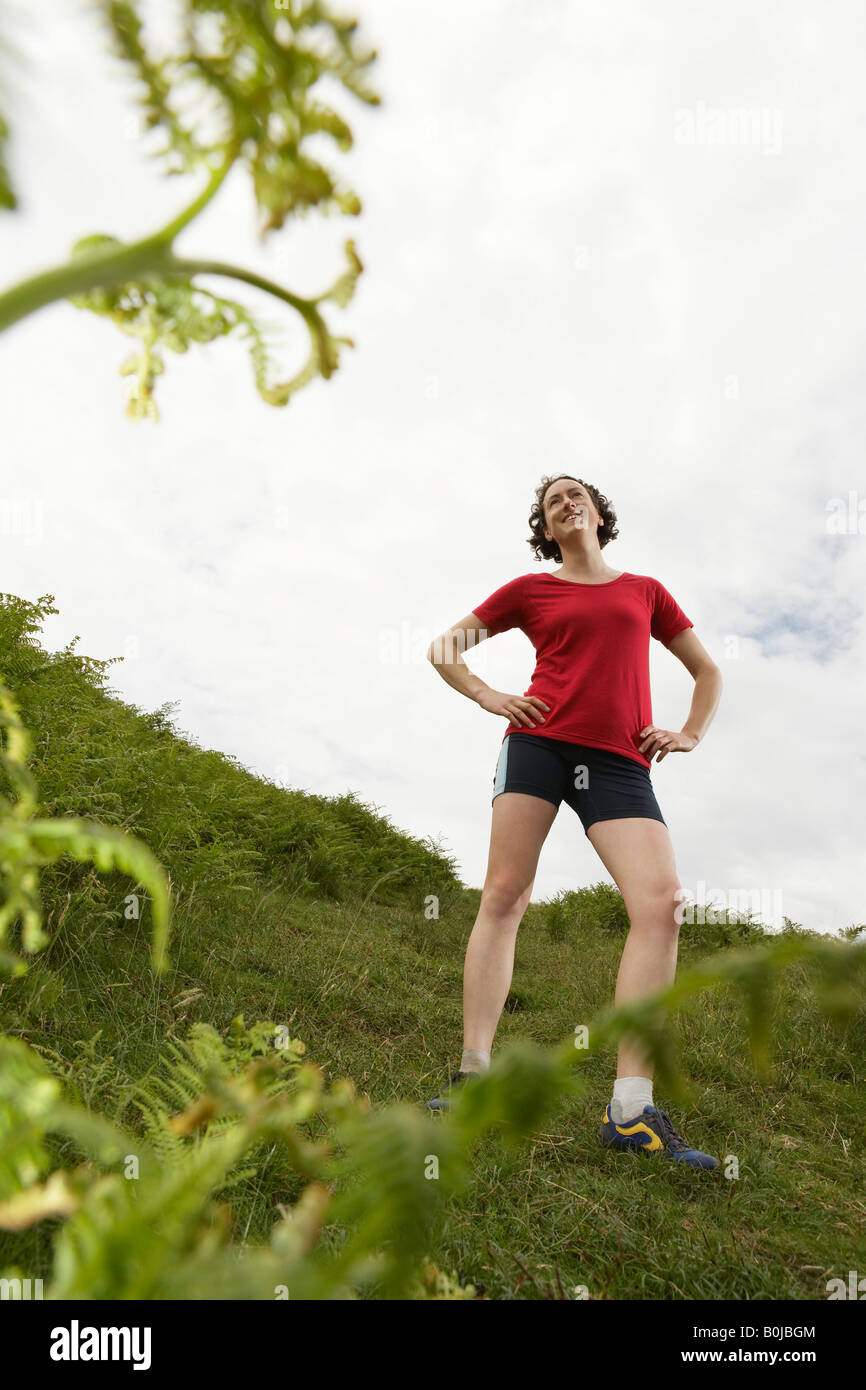 Frau mit Händen auf den Hüften in Landschaft Stockfoto