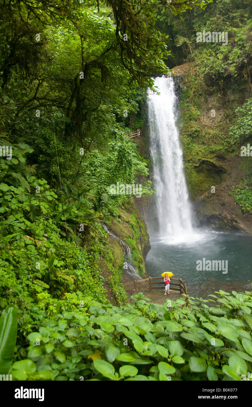 COSTA RICA La Paz Wasserfall Gärten spektakuläre Magia Blanca Wasserfälle Frau mit gelben Regenschirm auf die Aussichtsplattform. Stockfoto