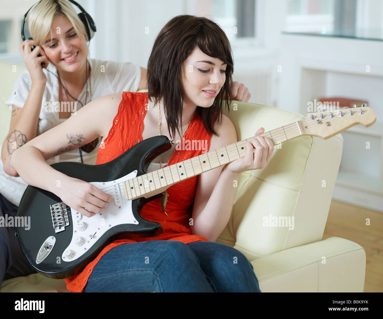 Junge Frauen spielen E-Gitarre Stockfoto