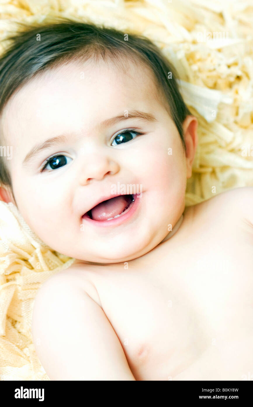 Baby liegend auf gelben Shag Teppich lachen Stockfoto