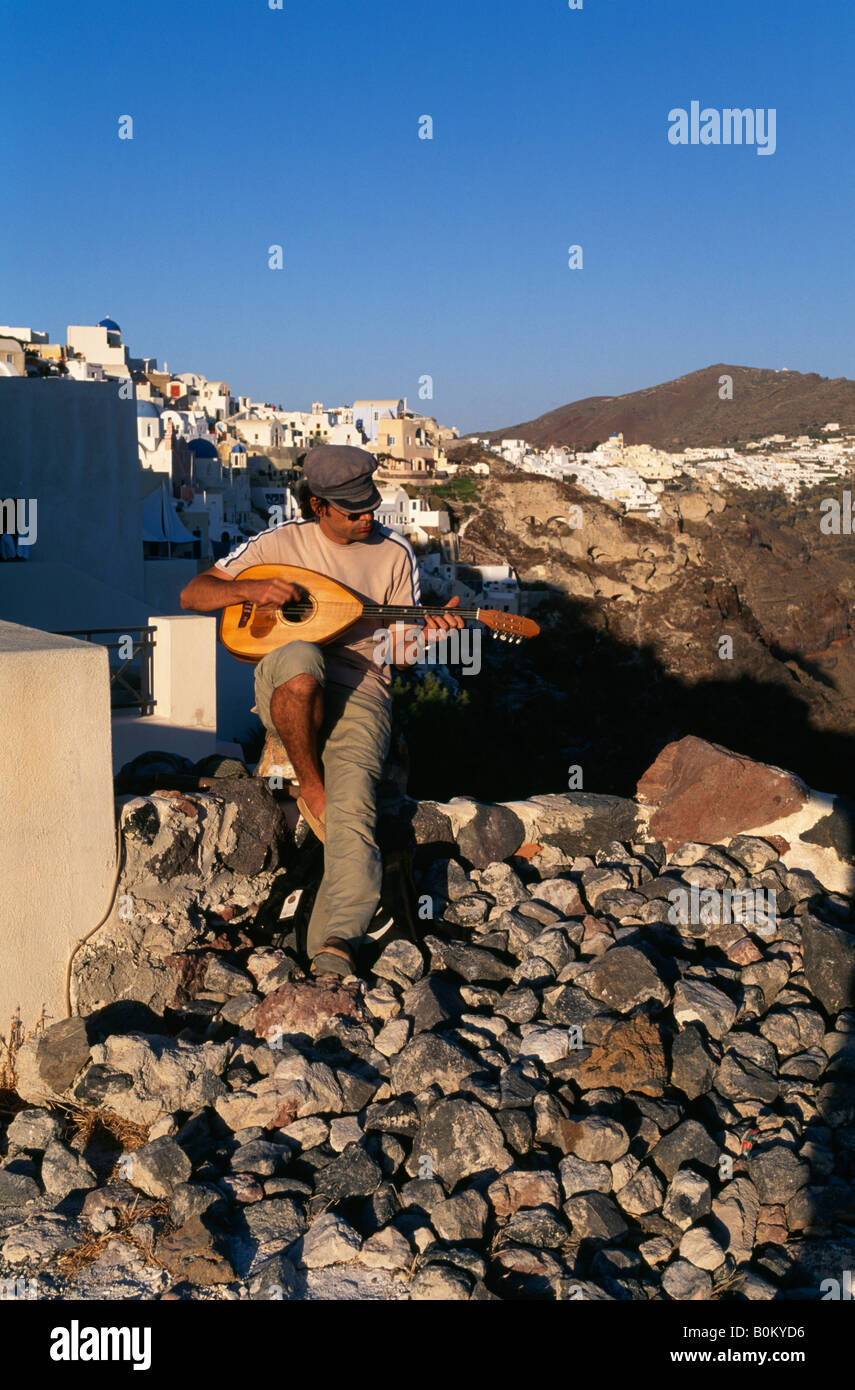 Ein Musiker spielt eine Mandoline auf Klippe in Oia Santorini griechische Inseln Griechenland Stockfoto