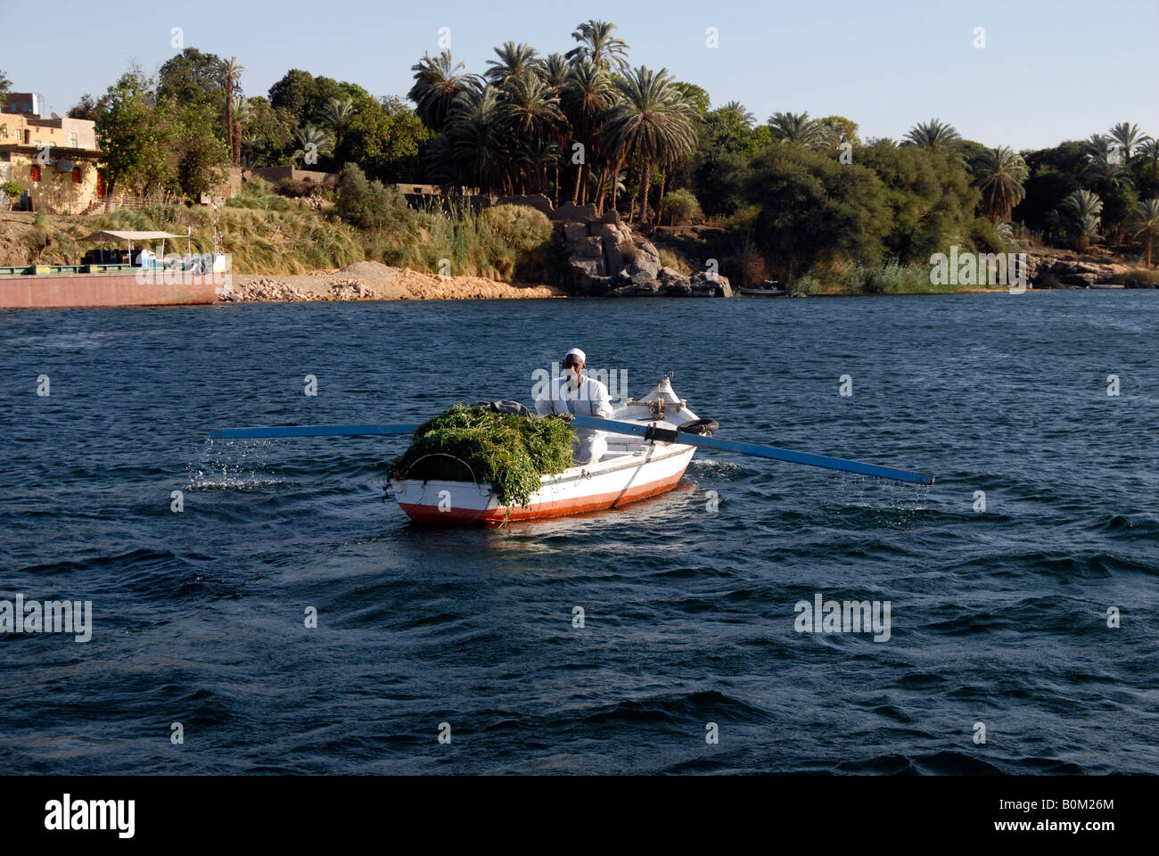 Ein alter ägyptischer Rudern seine Angeln Boot vorbei an Elephantine Insel auf dem Fluss Nil Assuan Ägypten Stockfoto