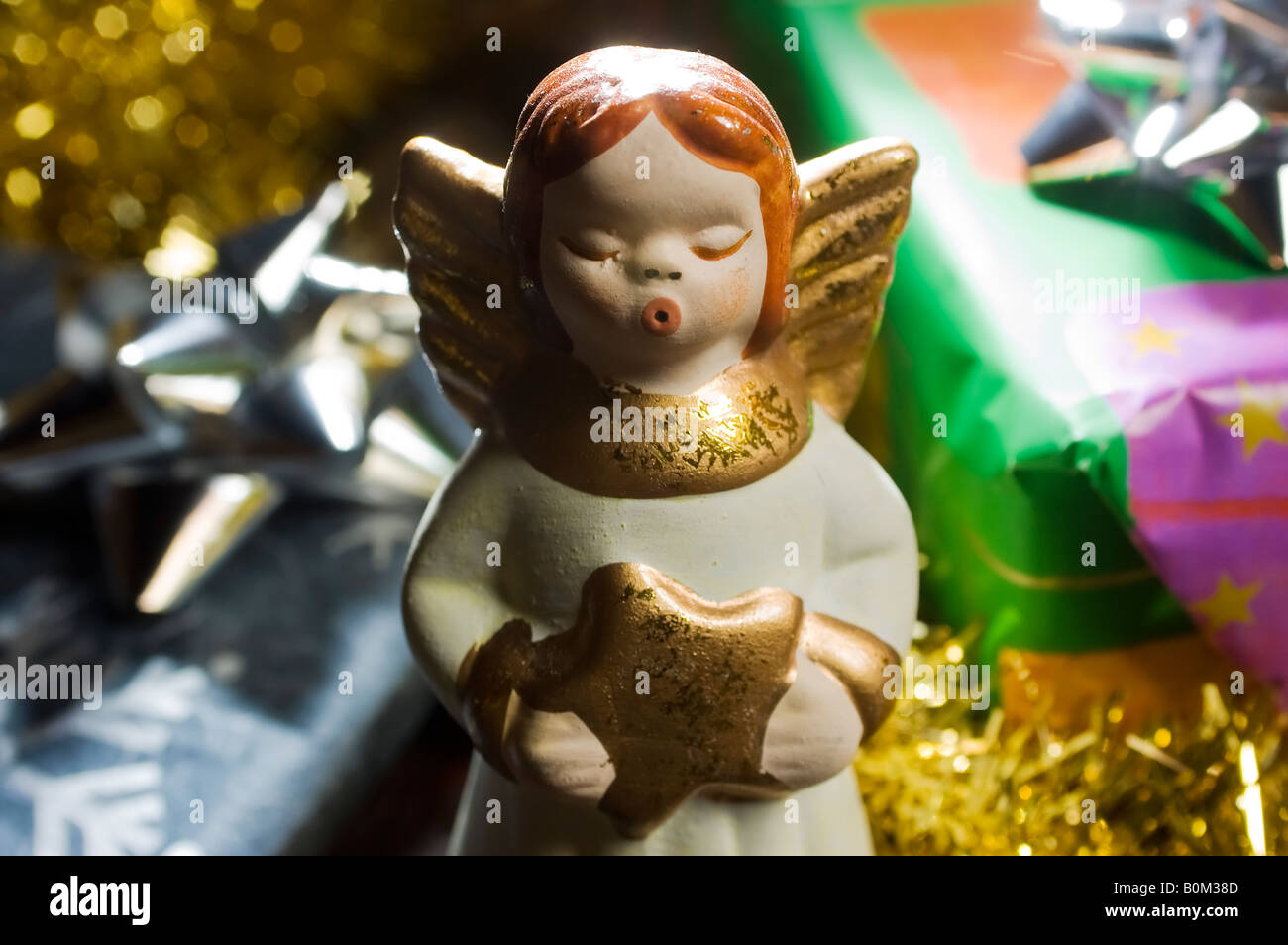 Weihnachten Engel mit goldenen Stern in der Hand Wistles Weihnachtslied unter bunten Geschenkboxen Stockfoto