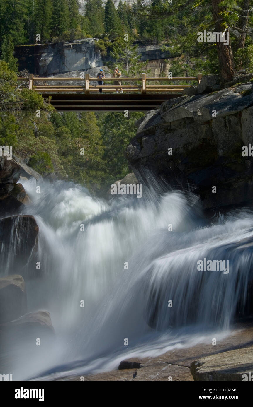 Wanderer auf Brücke über Kaskade am Merced River über Vernal Fall Yosemite Nationalpark, Kalifornien Stockfoto