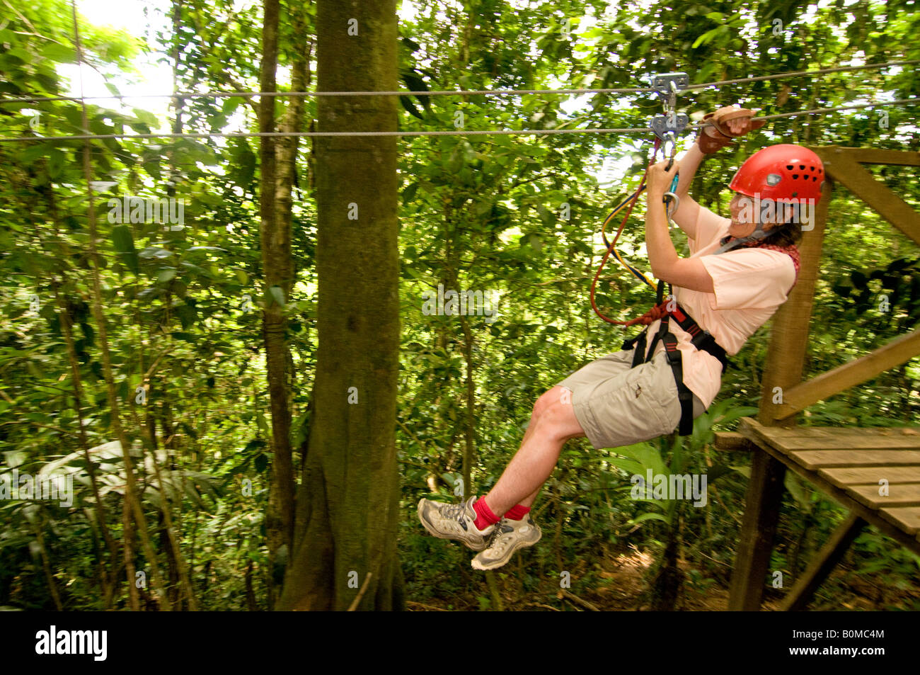 COSTA RICA Reife Frau eine gute Zeit Reißverschluss Futter auf einer Canopy Tour. Pacuare Fluss Lodge. Karibische Hang Stockfoto