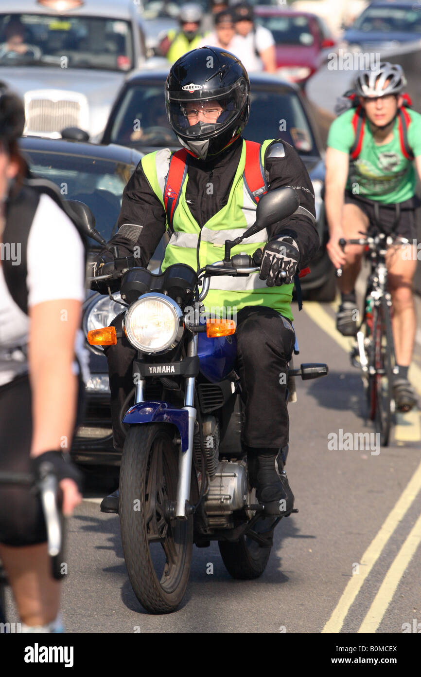 Pendlerverkehr in London Motorrad Motorradfahrer und Radfahrer Radfahrer fahren Sie durch Verkehrsstaus in Westminster Stockfoto