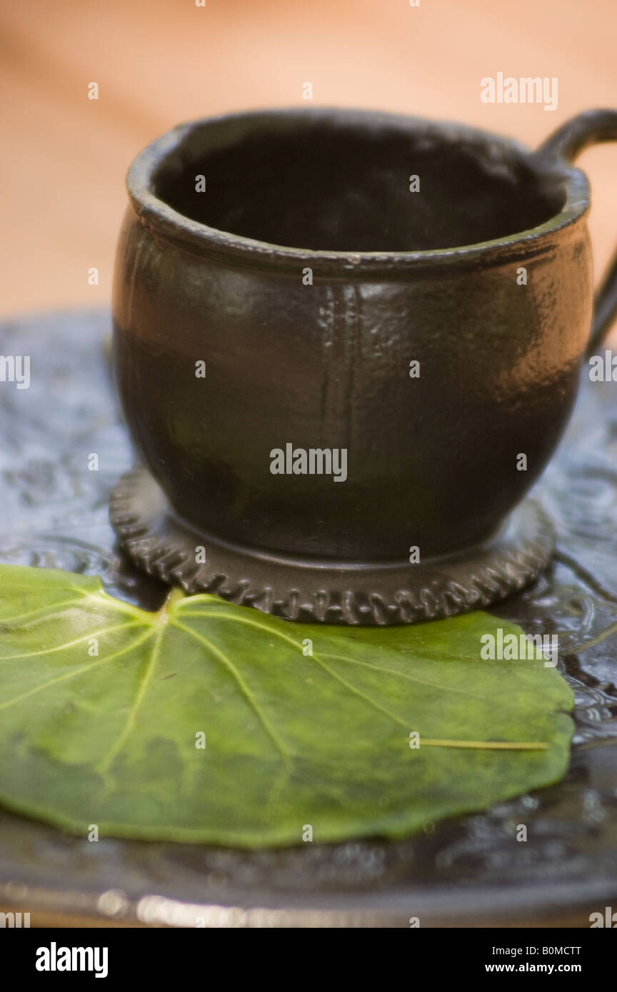 Schwarze Tasse Lehm und grün Seerose Blatt rustikale Garten-Accessoires und Dekoration Stockfoto