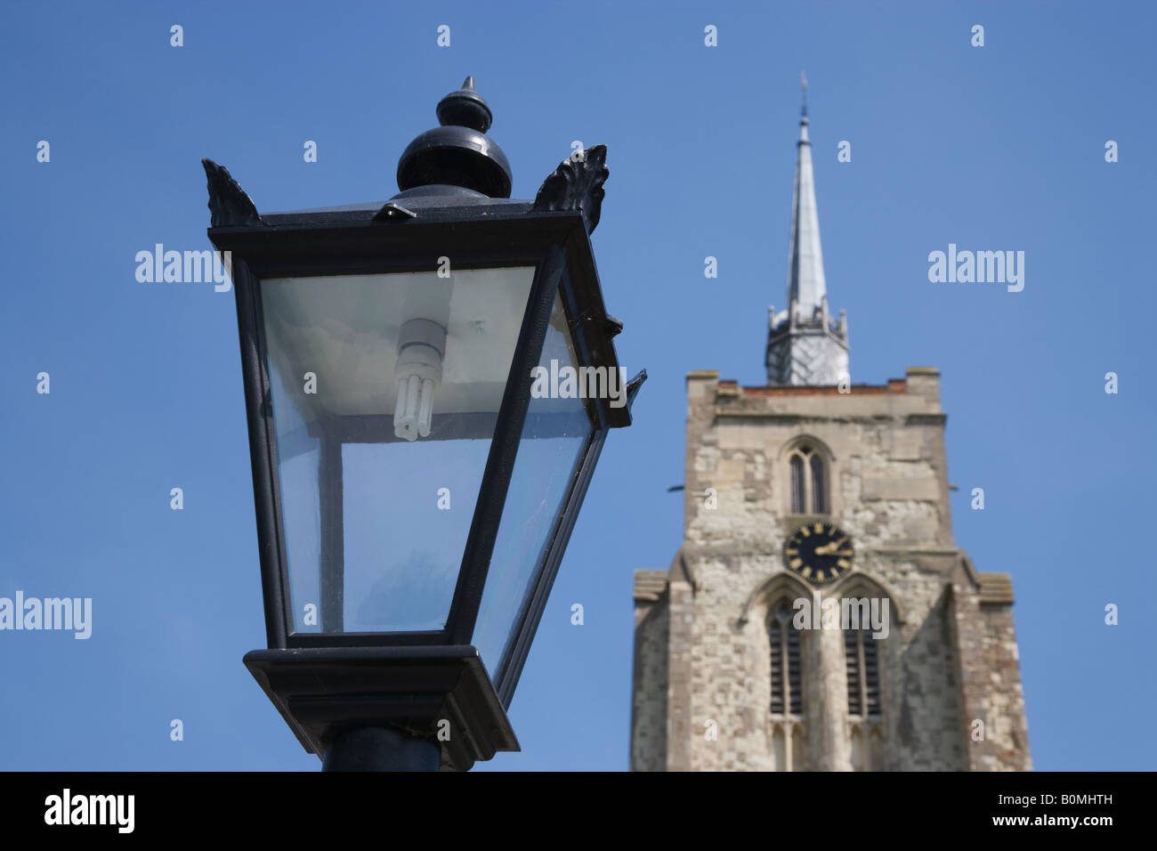 Traditionelle Straßenleuchte ausgestattet mit einer Energiesparlampe vor St Mary die Jungfrau Ashwell Hertfordshire UK Stockfoto