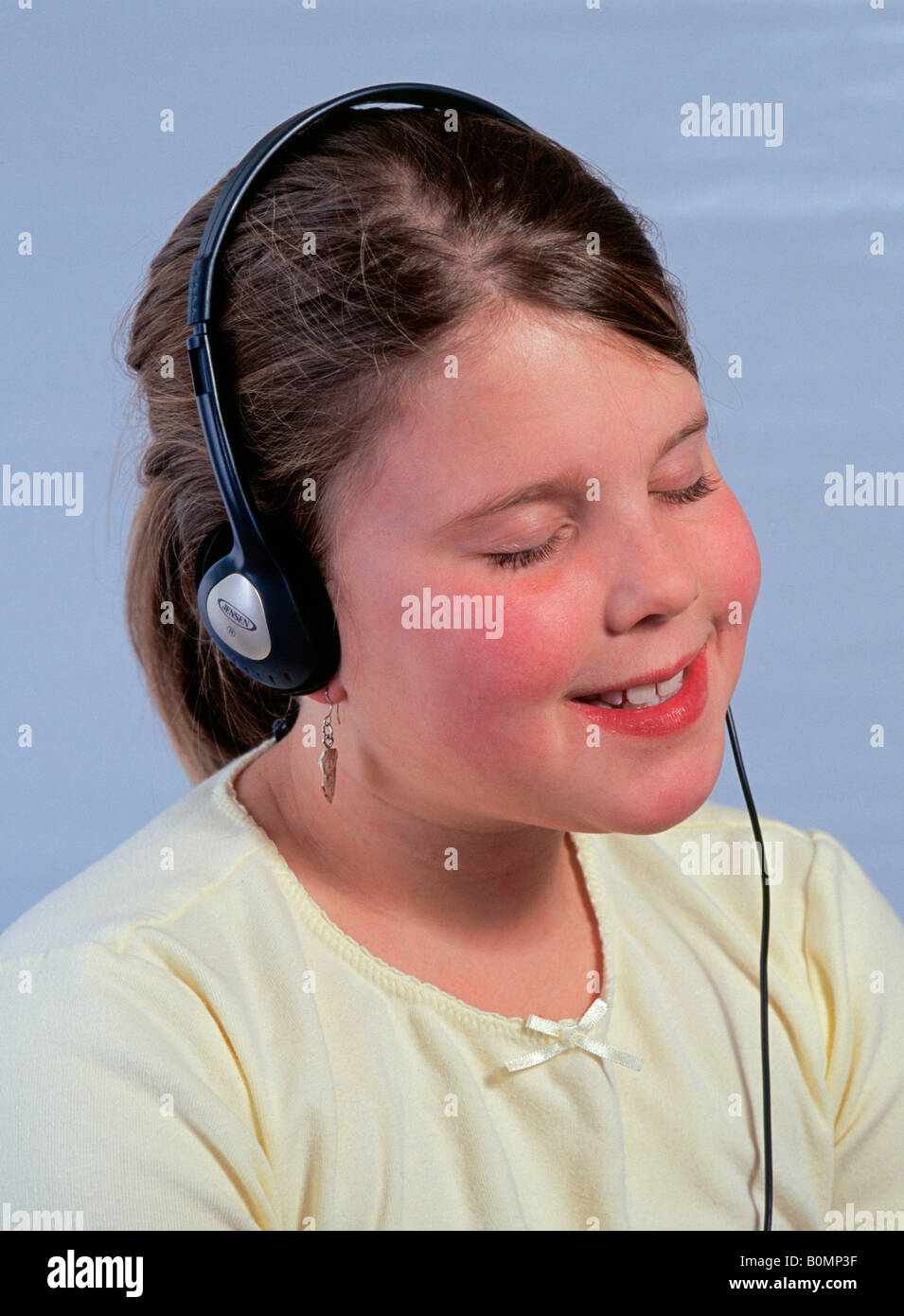 Ein 11 elfjährige Mittelschule Mädchen hören von ihrem Ipod auf Kopfhörern Stockfoto