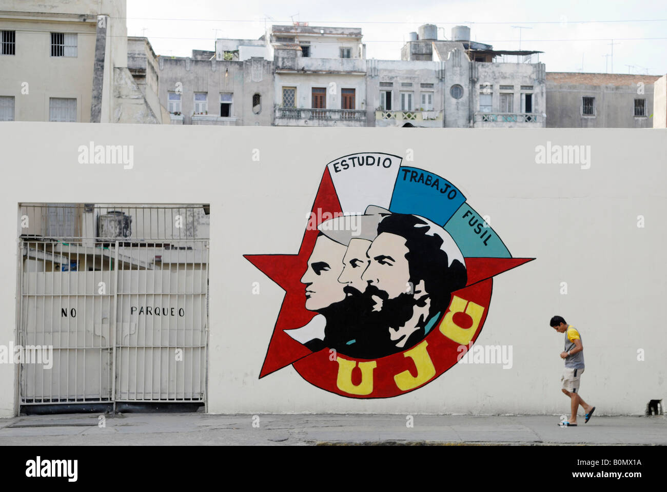 Ein Propaganda-Gemälde der jungen Kommunistischen Liga UJC an eine Wand und ein Fußgänger in Havanna Kuba April 2007 Stockfoto
