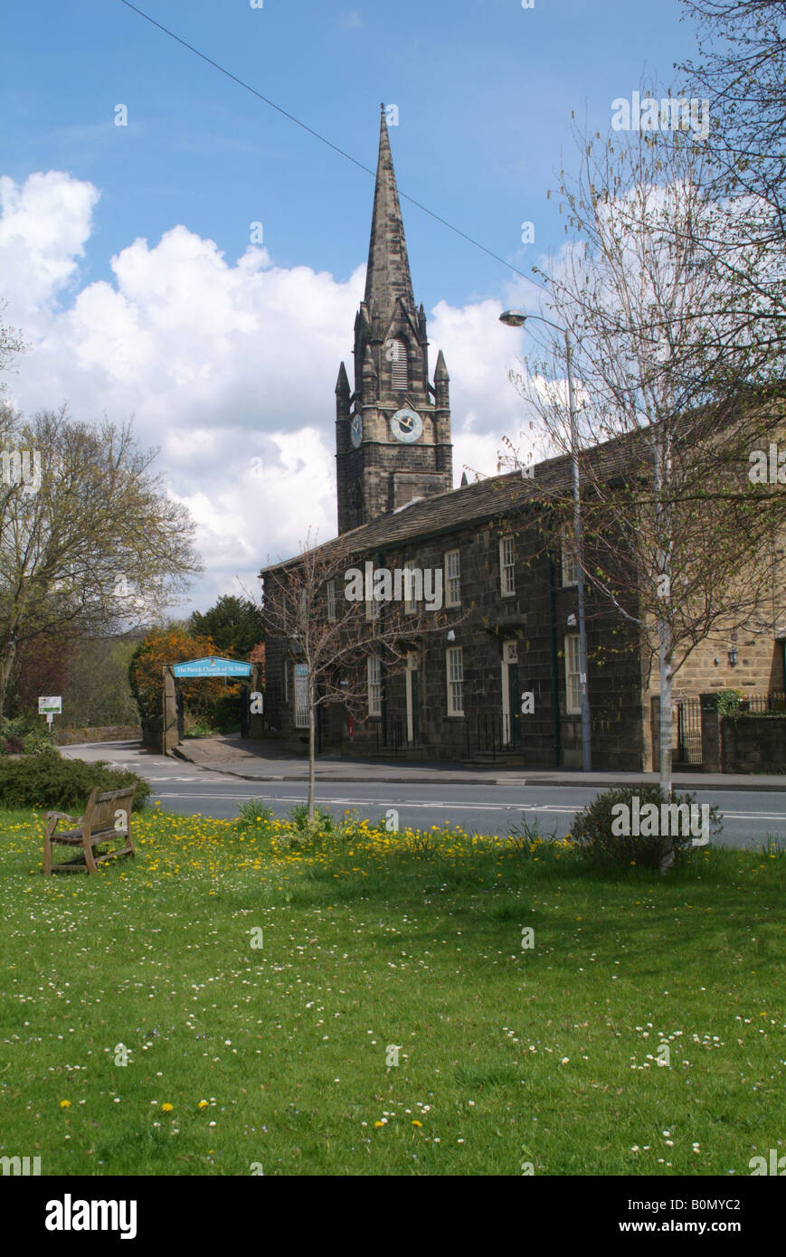 Der Turm von der Pfarrkirche St. Mary steigt über Reihenhäuser in Main Street Burley in Wharfedale Stockfoto